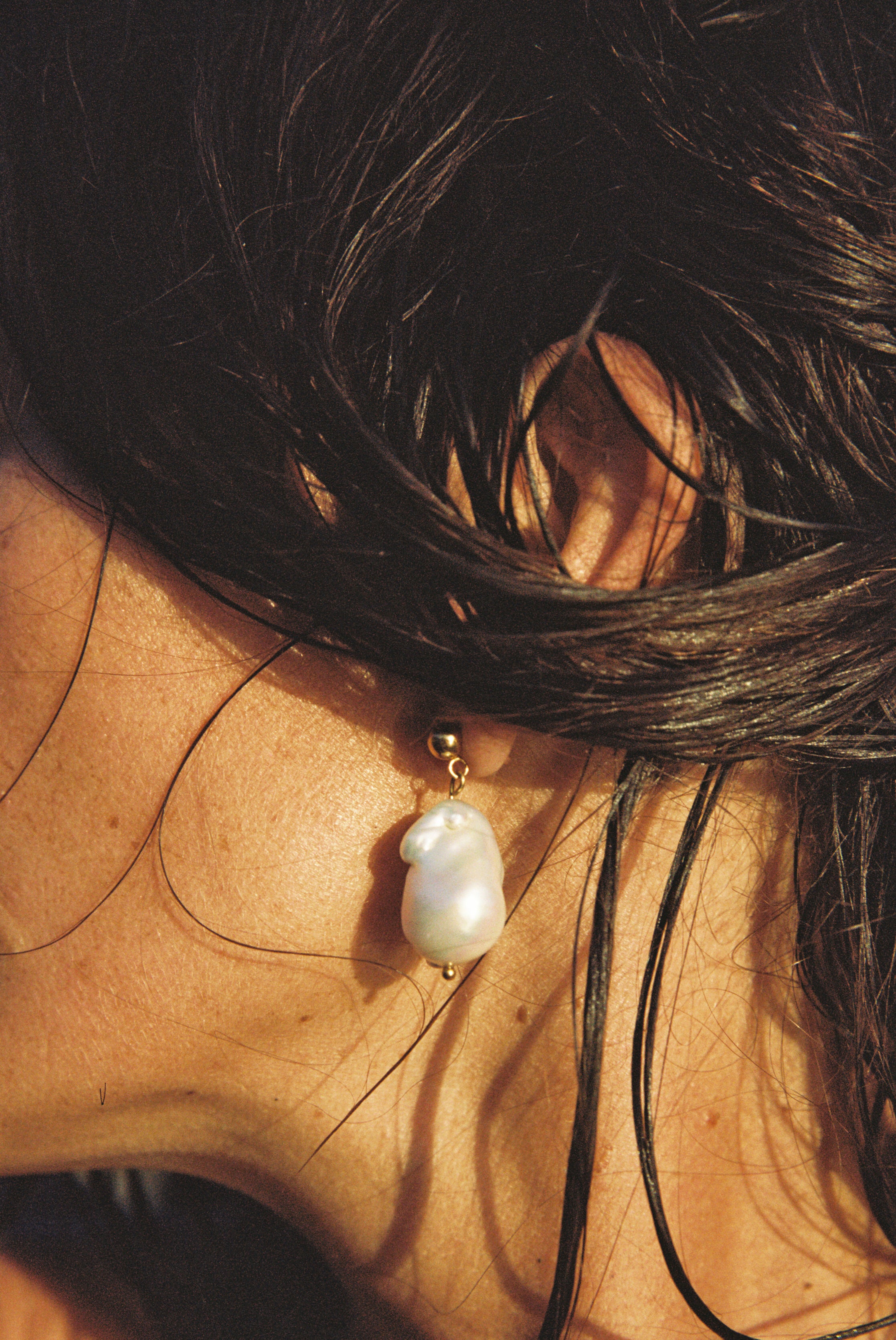 Close-up of real freshwater baroque pearl earrings on woman