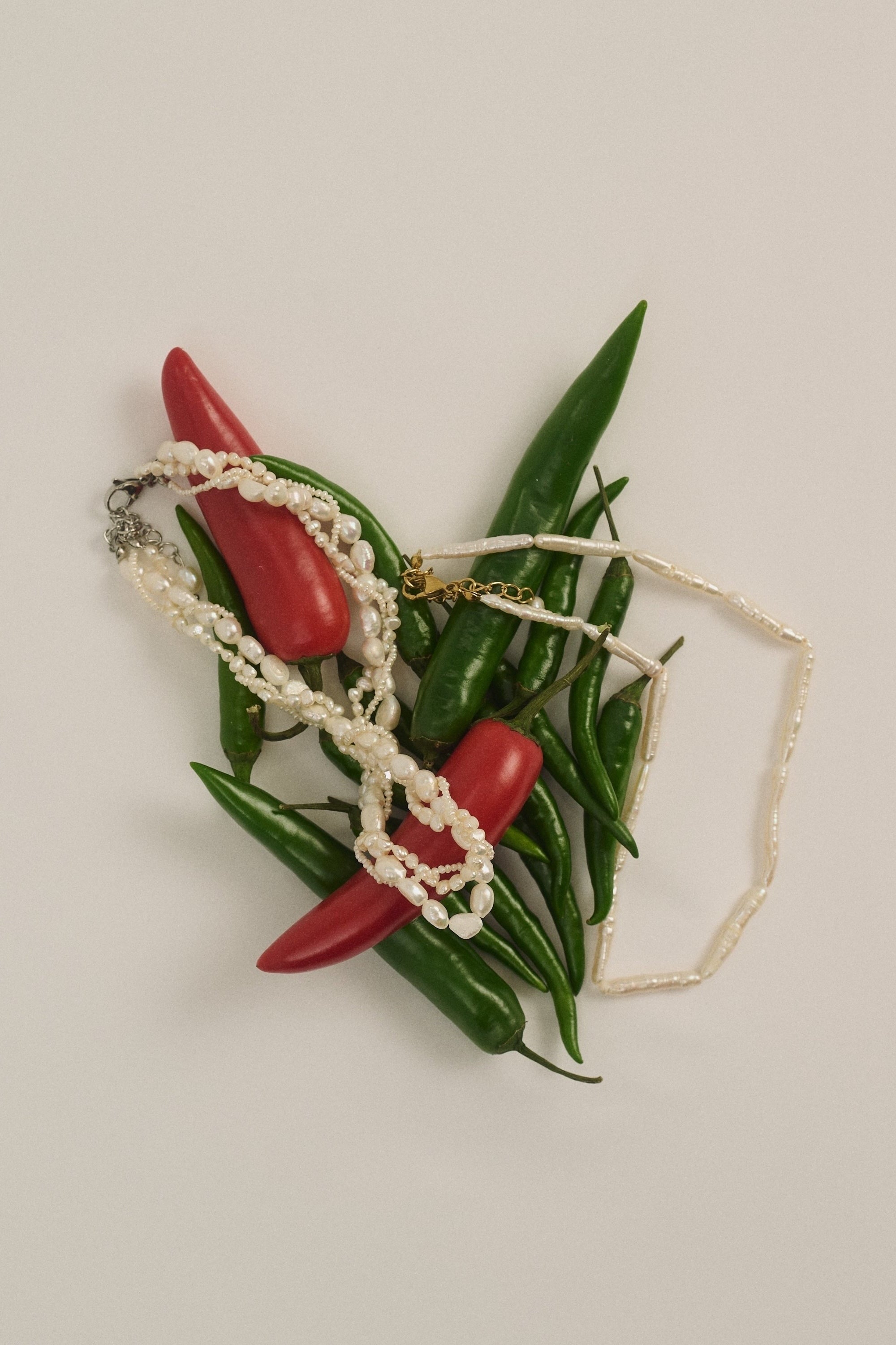 Braided freshwater pearl choker styled with red and green peppers