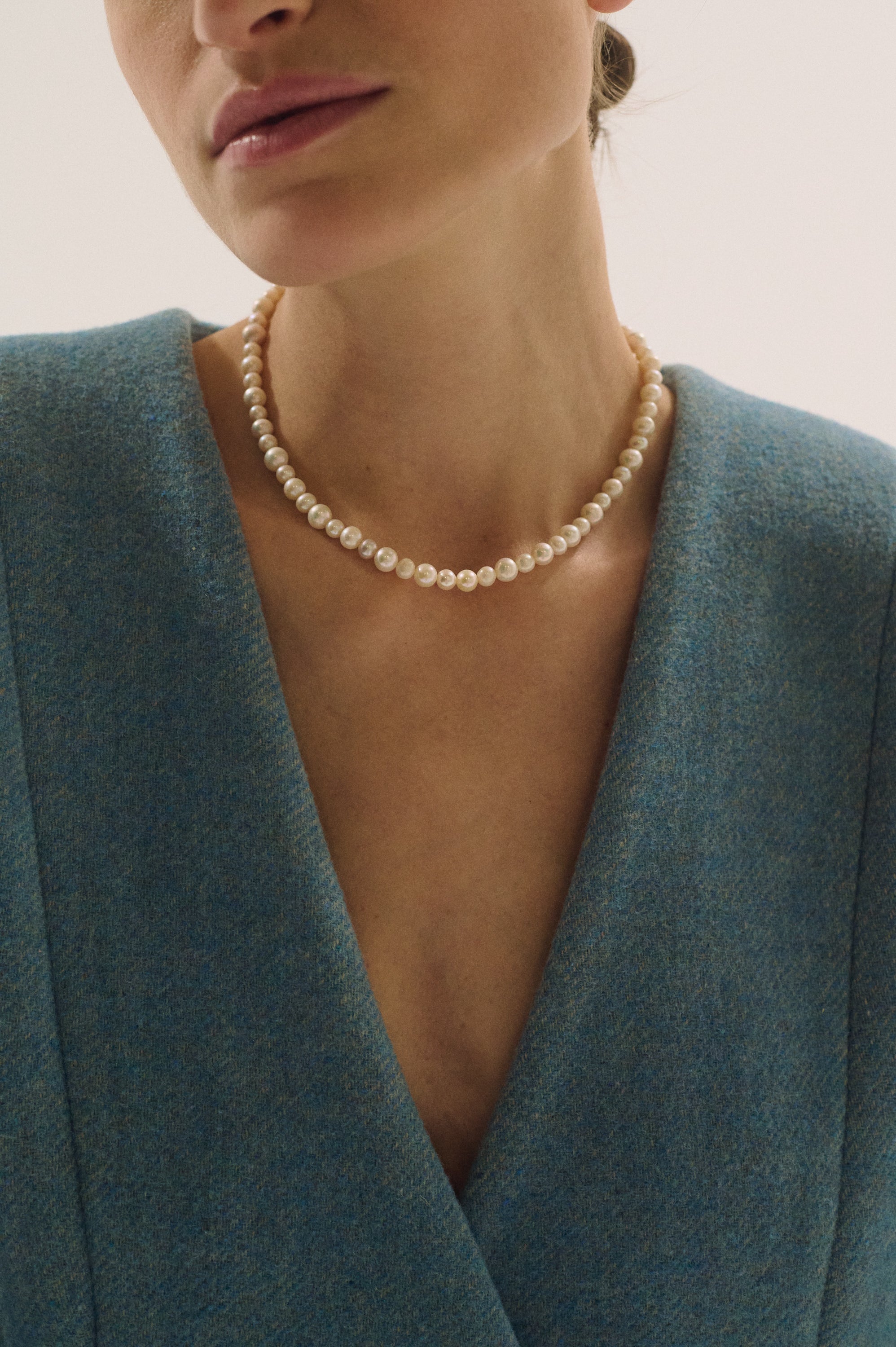 Model wearing classic round pearl necklace with blue blazer – UGNÈS STORY