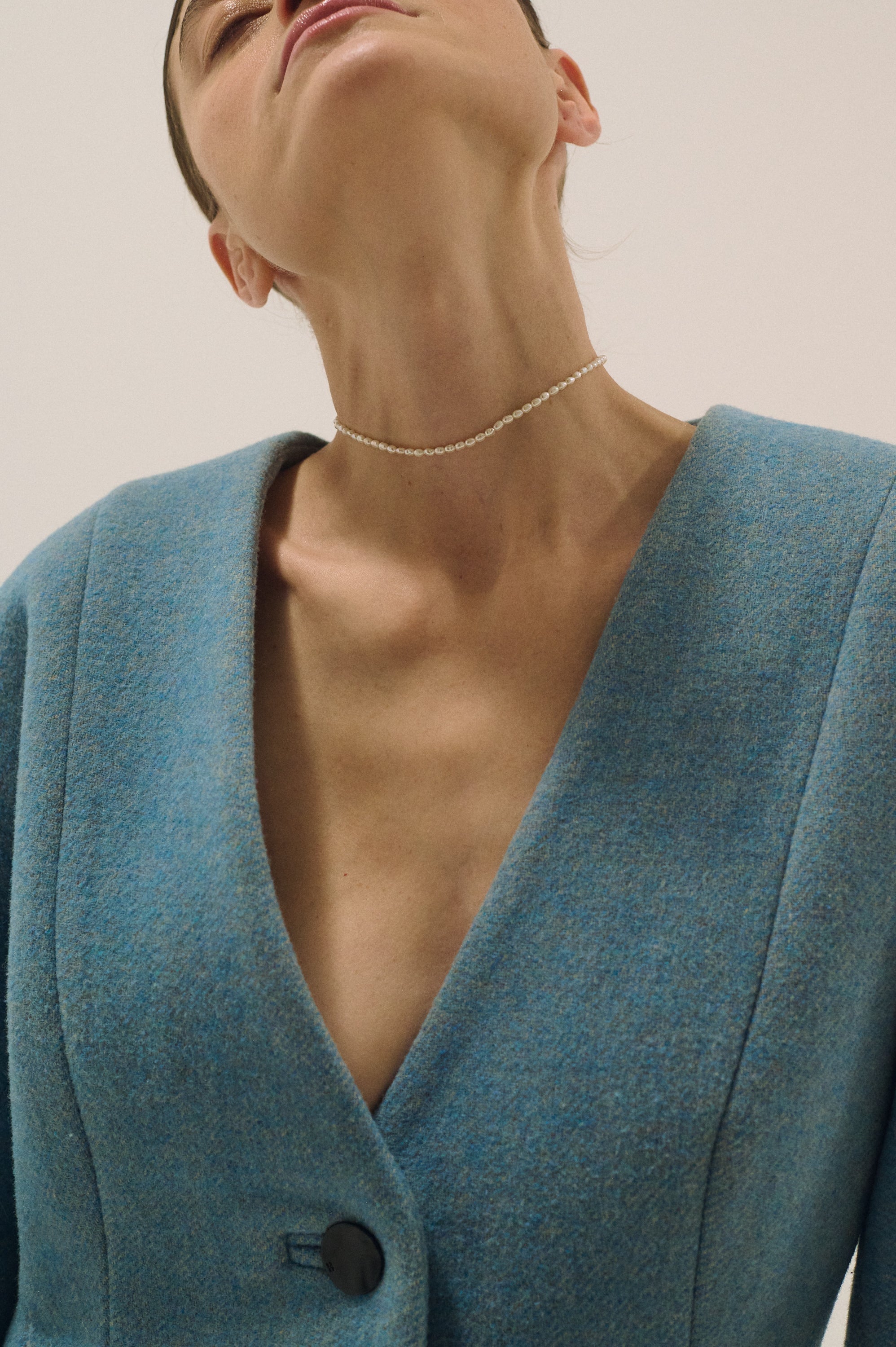 Close-up of minimalist pearl choker with small natural pearls on the neck