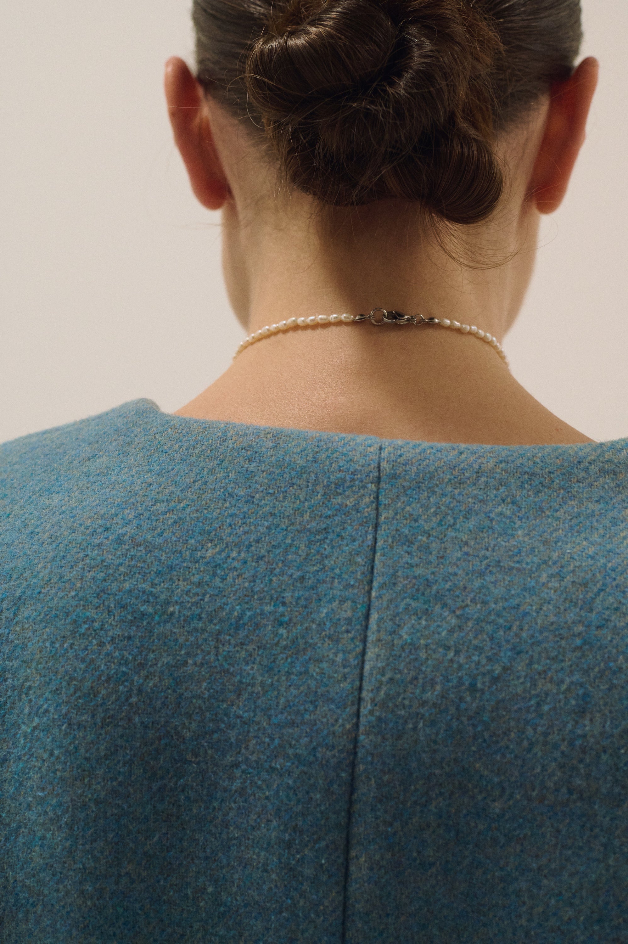 Back view of delicate tiny pearl choker necklace with silver clasp