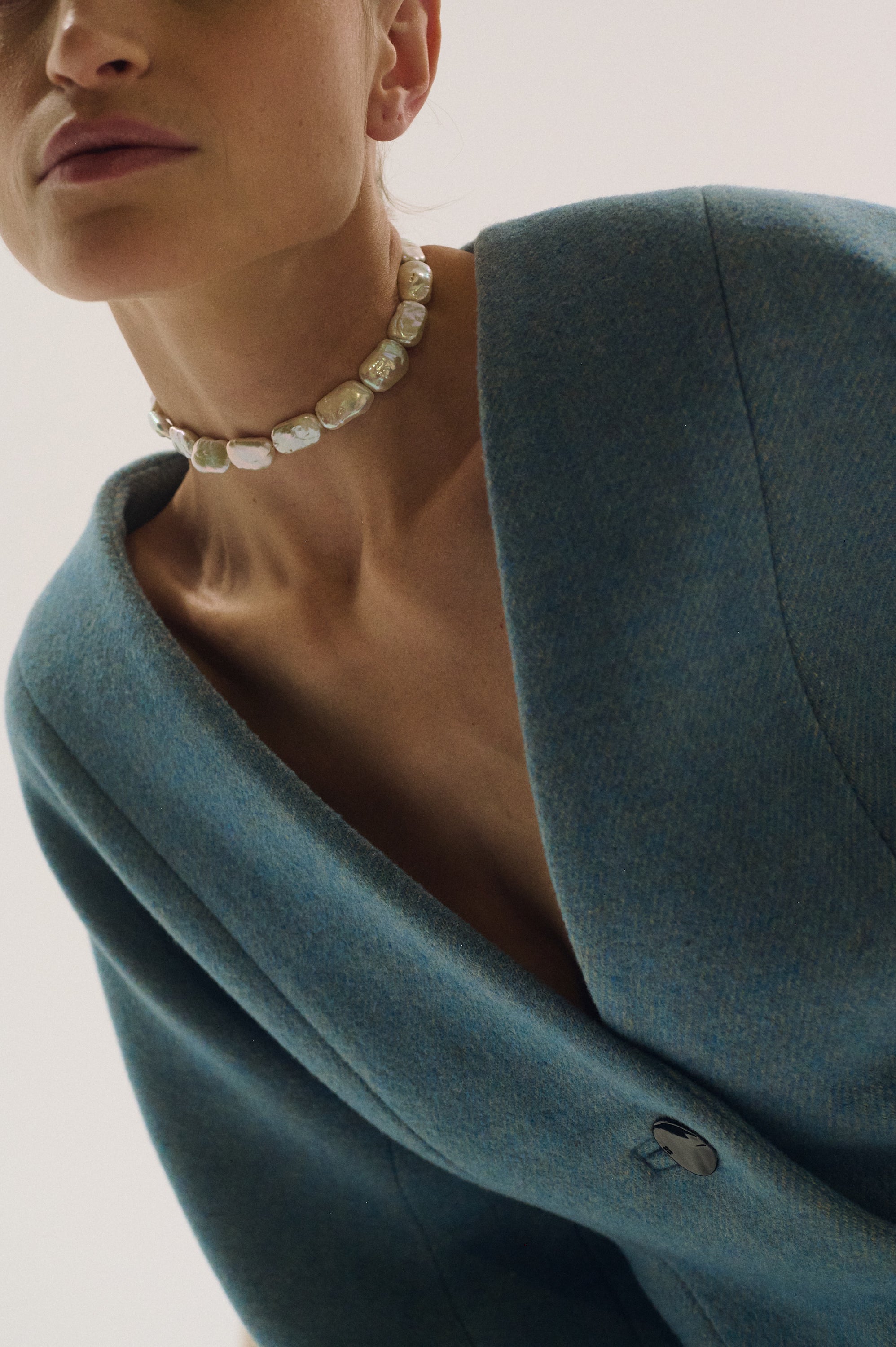 Close-up of flat rectangular pearl choker on model