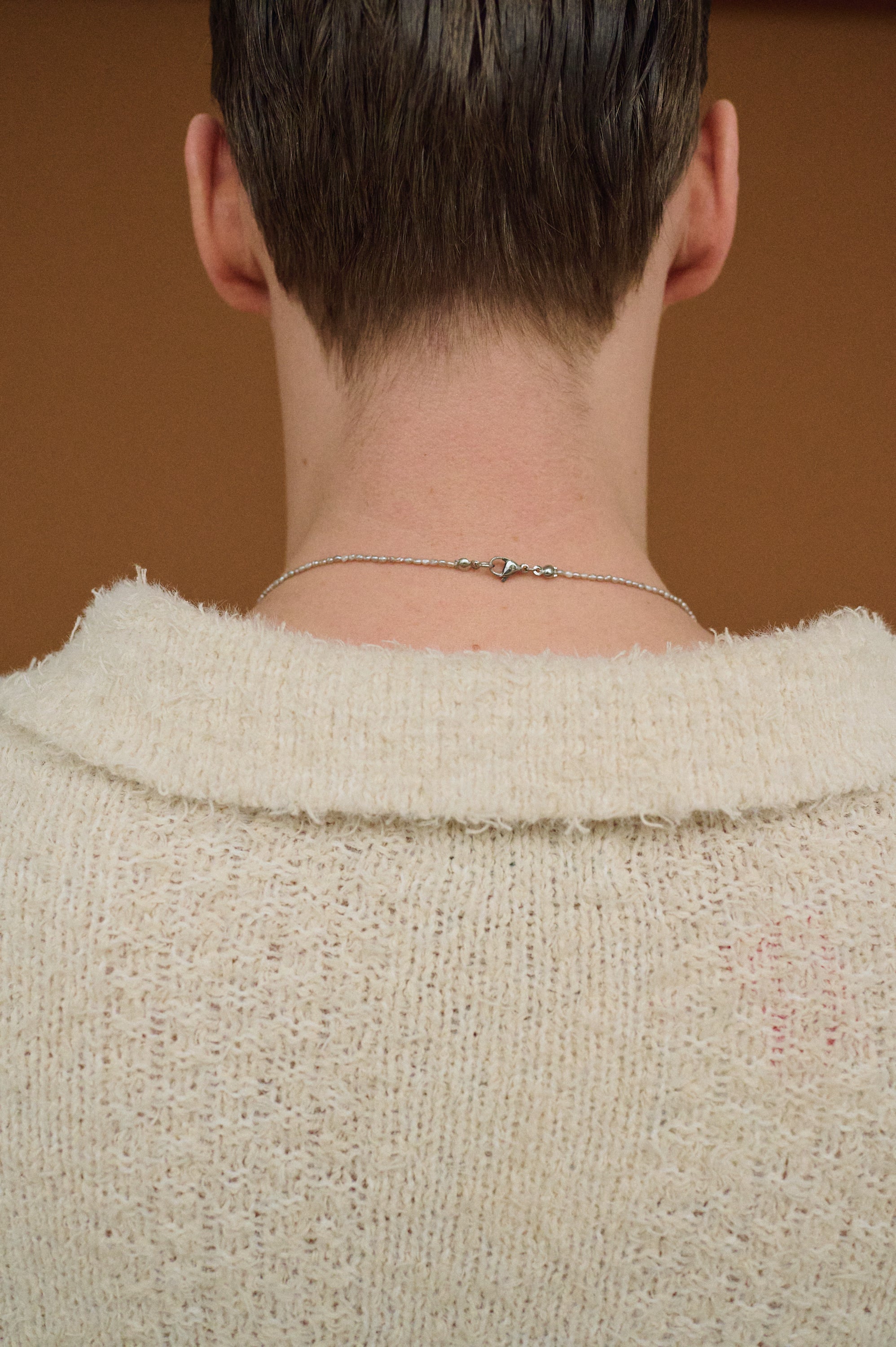 Clasp detail of men’s pearl necklace, stainless steel with silver plating