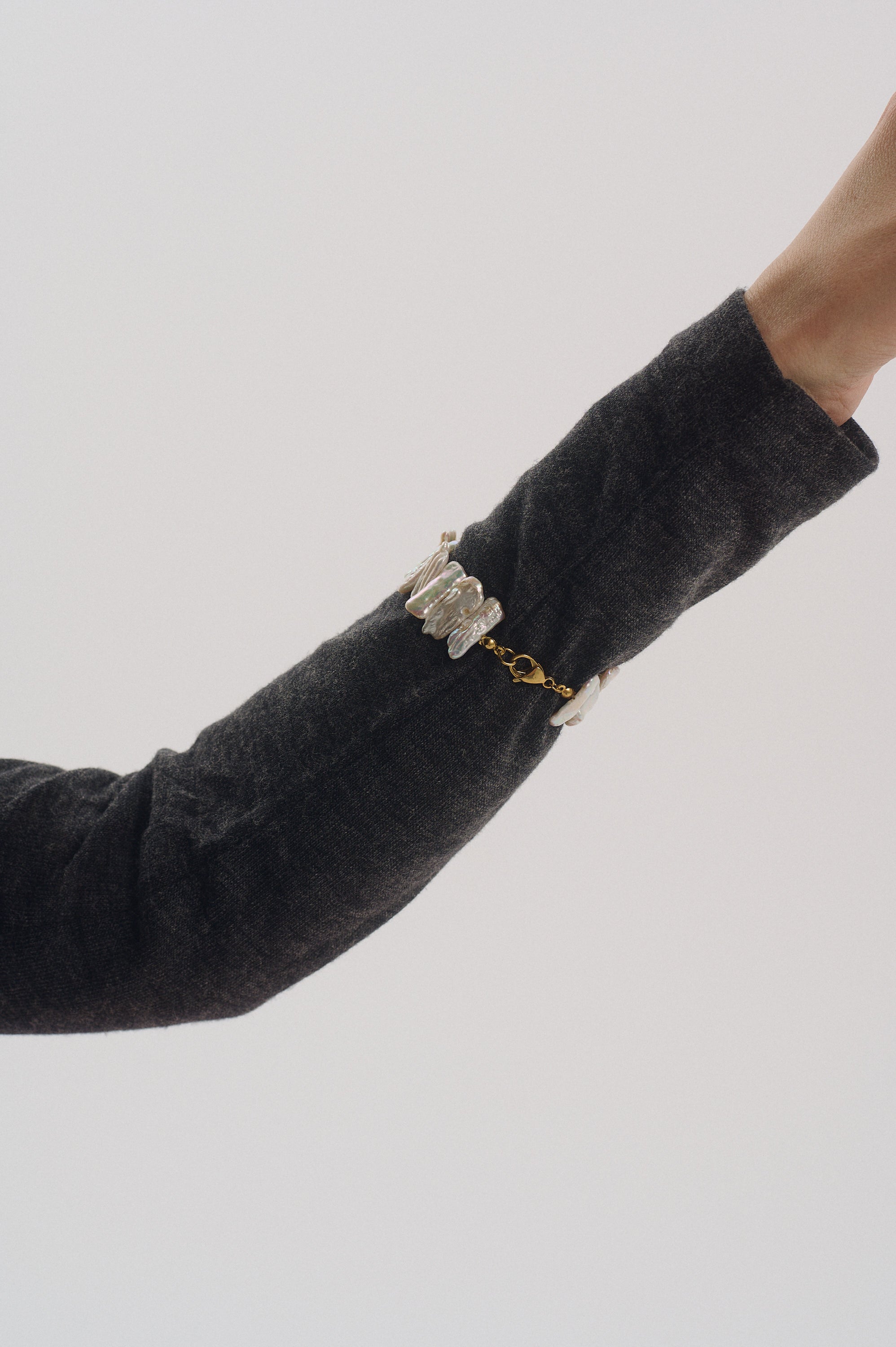 White Keshi pearl bracelet with gold clasp on wrist