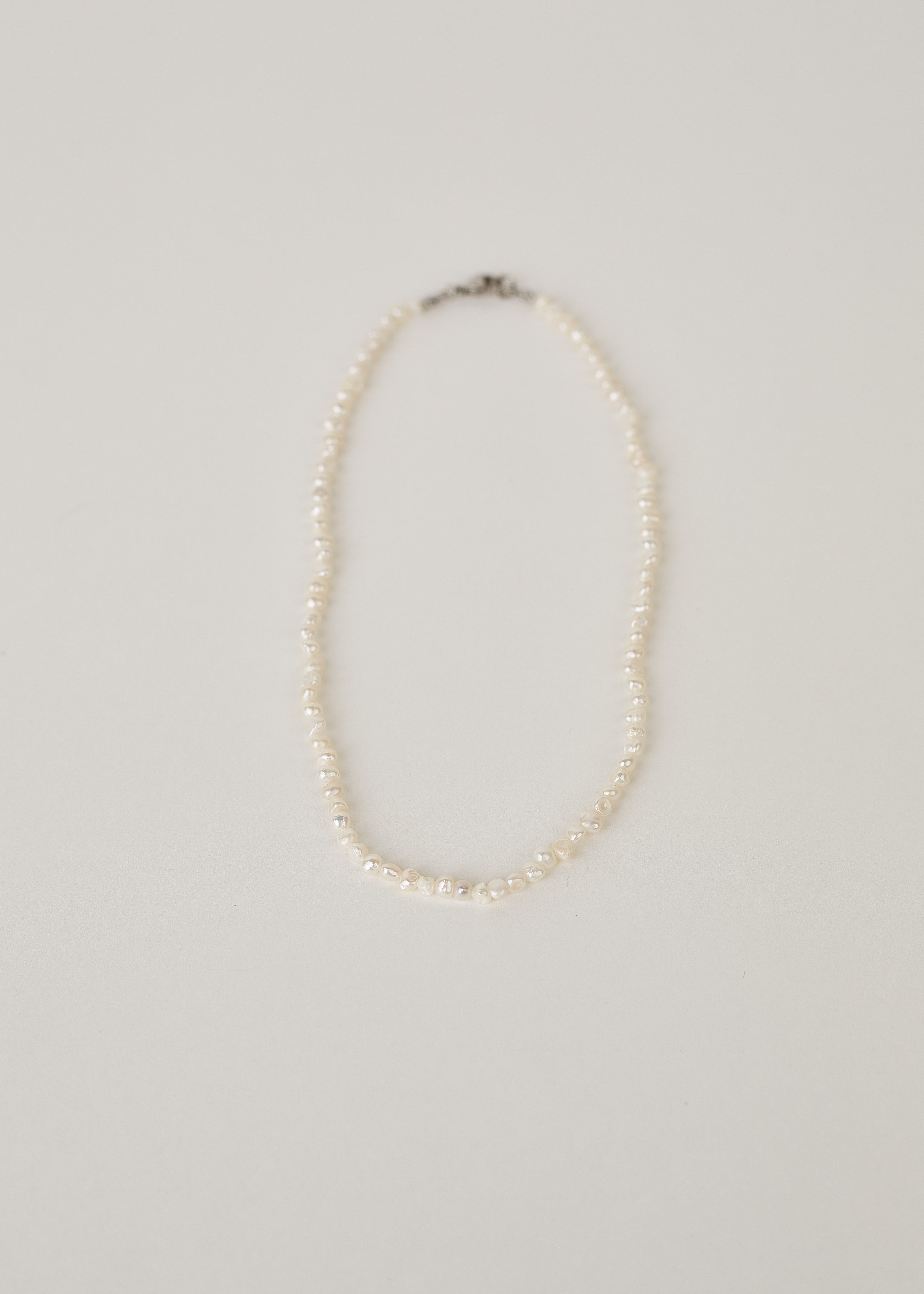 Pearl necklace on a light gray background