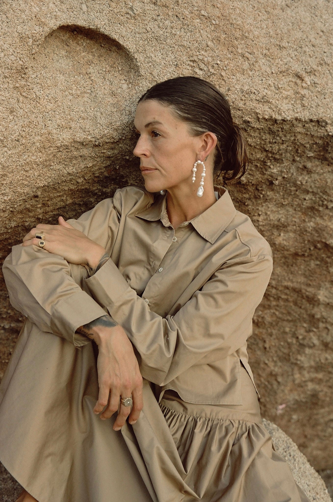 Handmade freshwater pearl dangle earrings on rocky background