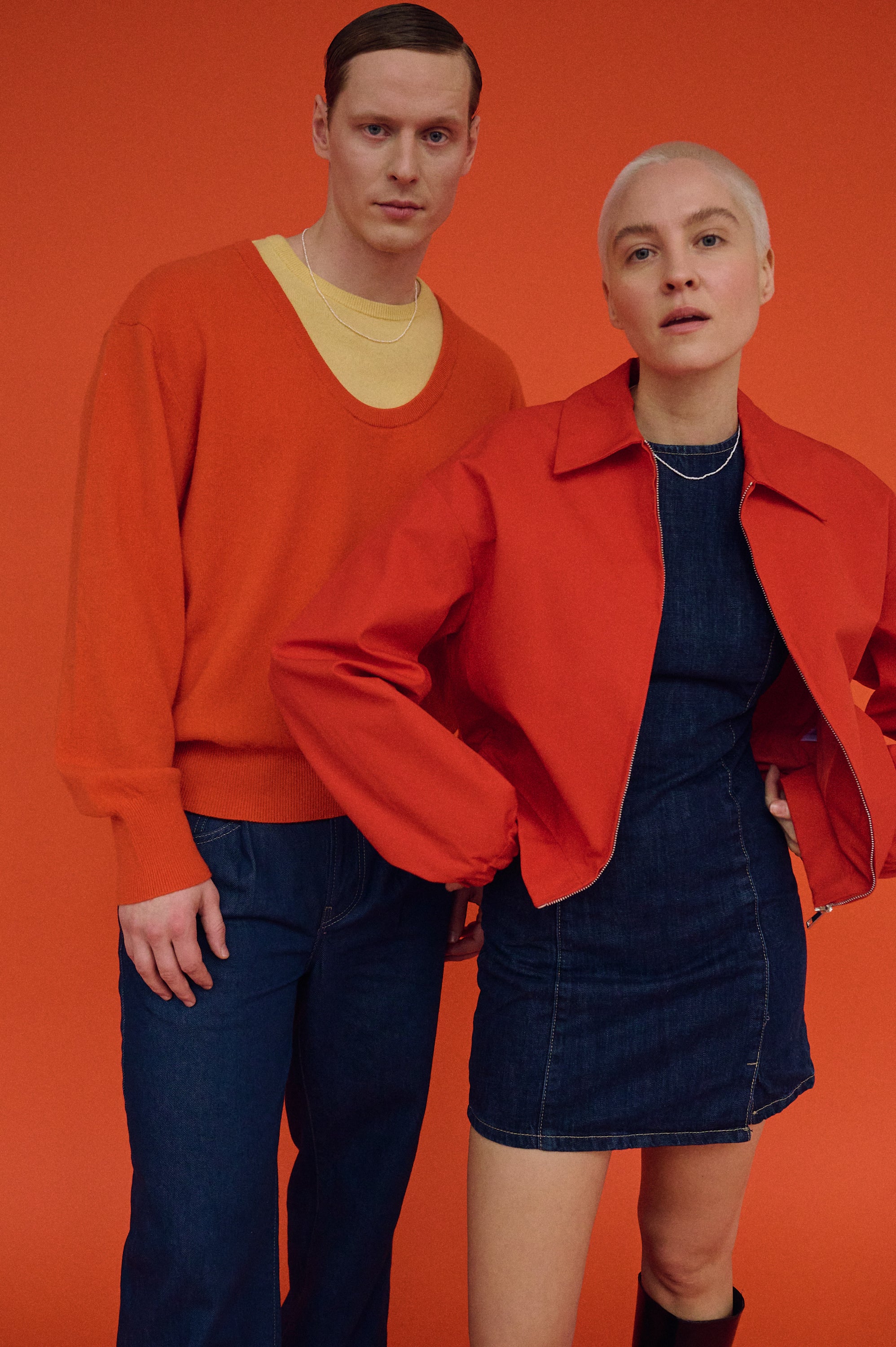 Man and woman in casual outfits layered with minimalist pearl necklaces.