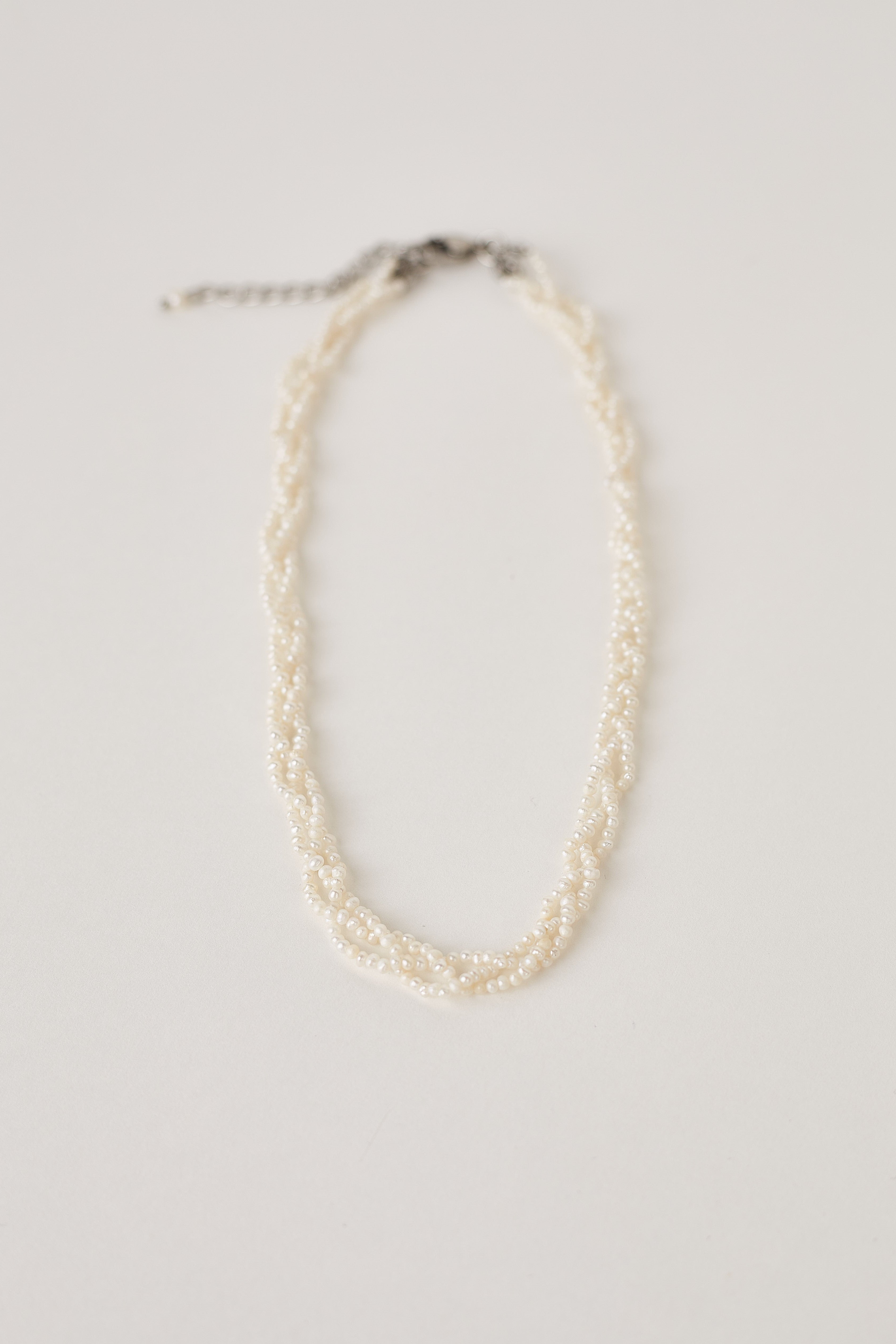 Multistrand real tiny white Pearl necklace on a light gray background