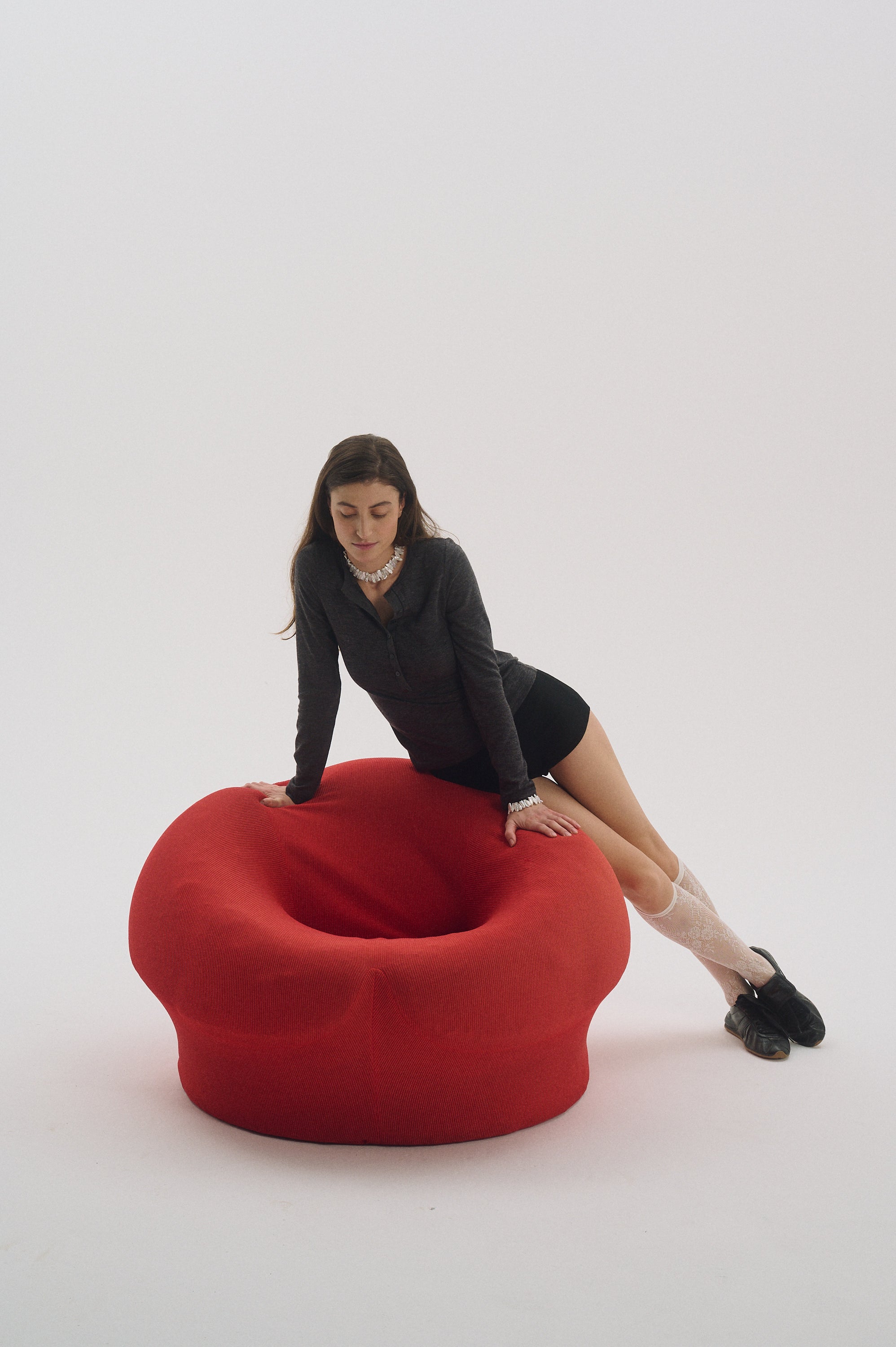 Model wearing White Keshi pearl necklace and bracelet set in red chair