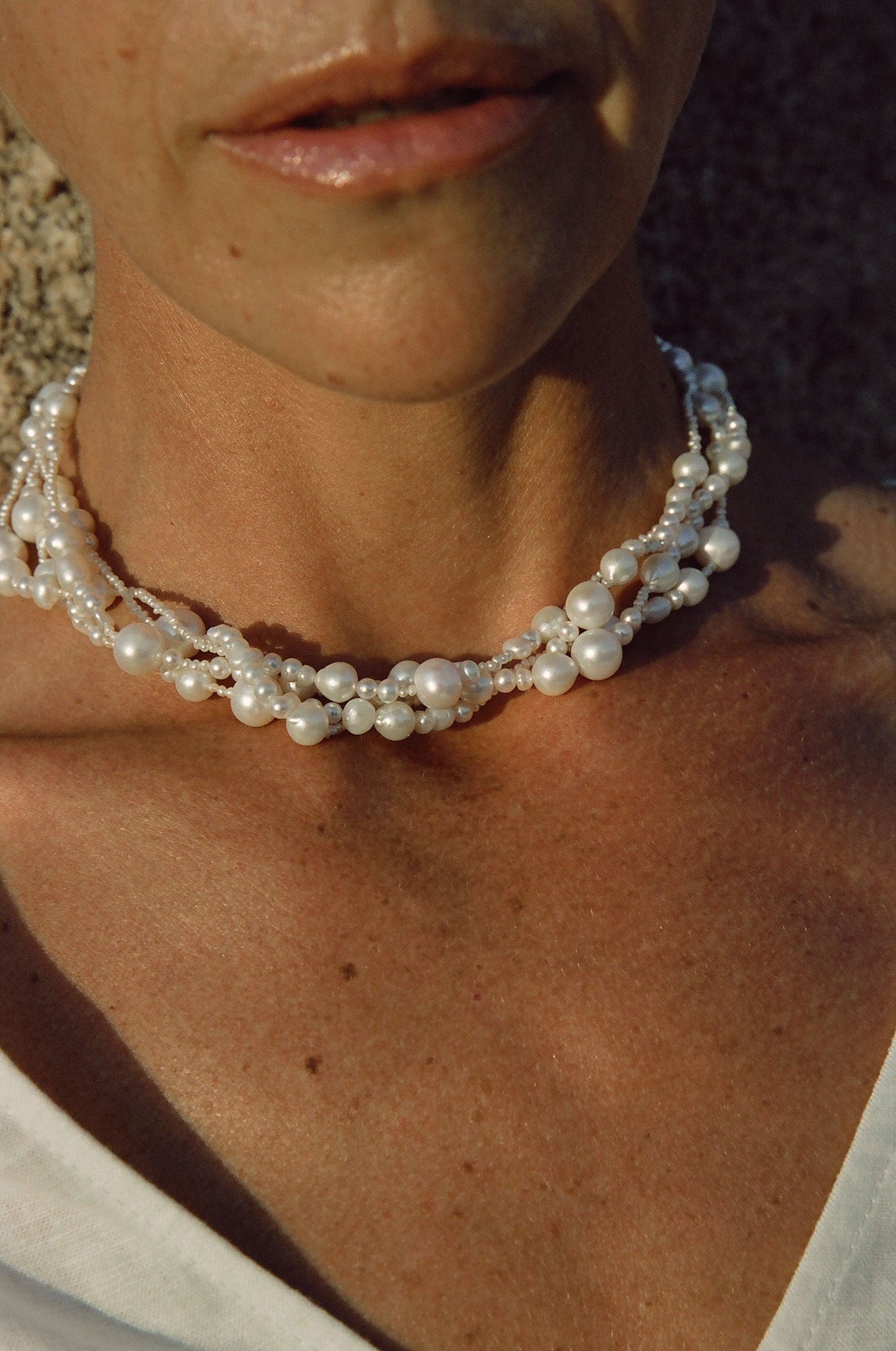 close-up of chunky pearl necklace with multiple strands on model