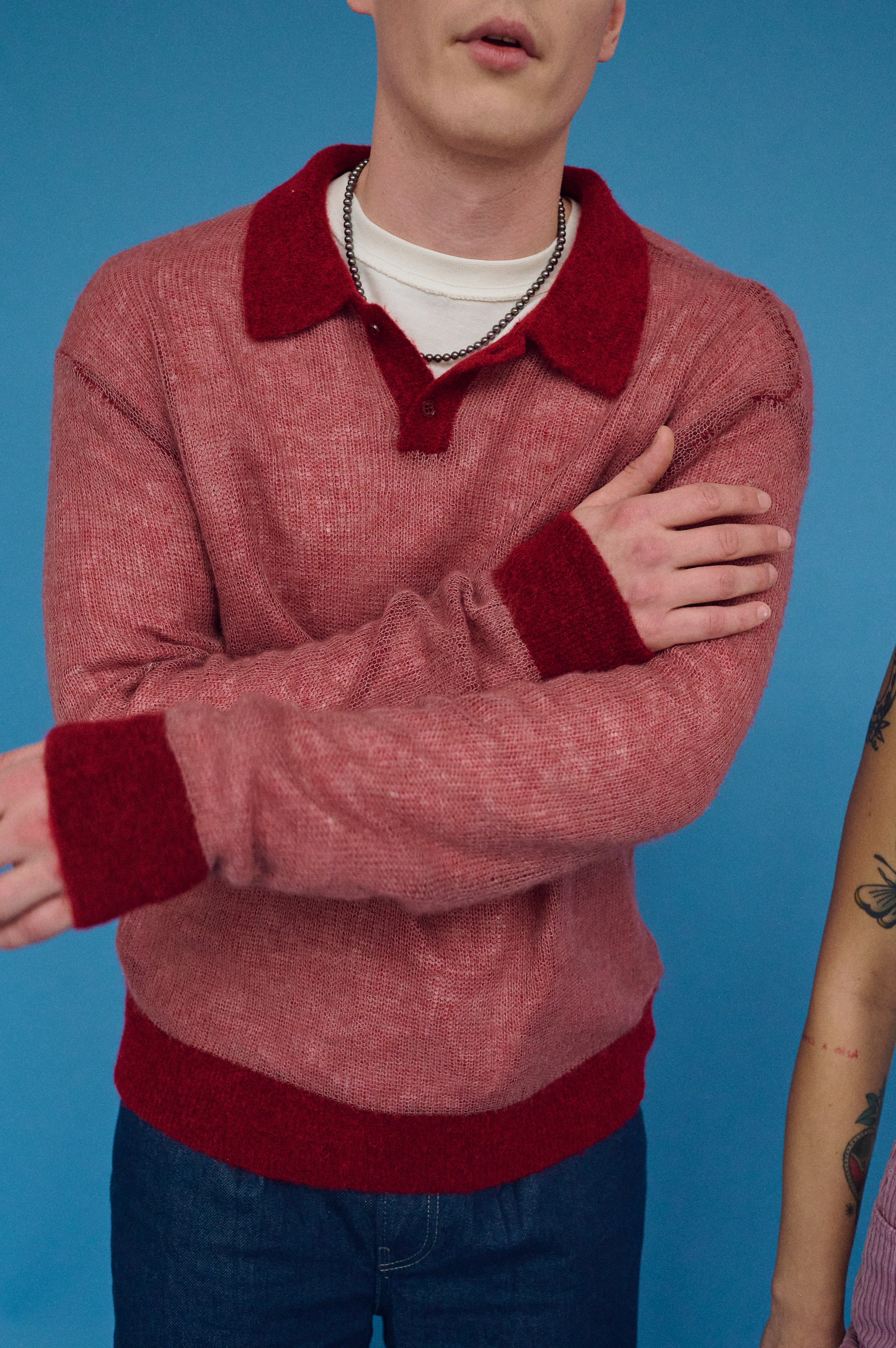 Stylish men’s dark pearl choker with red sweater outfit.