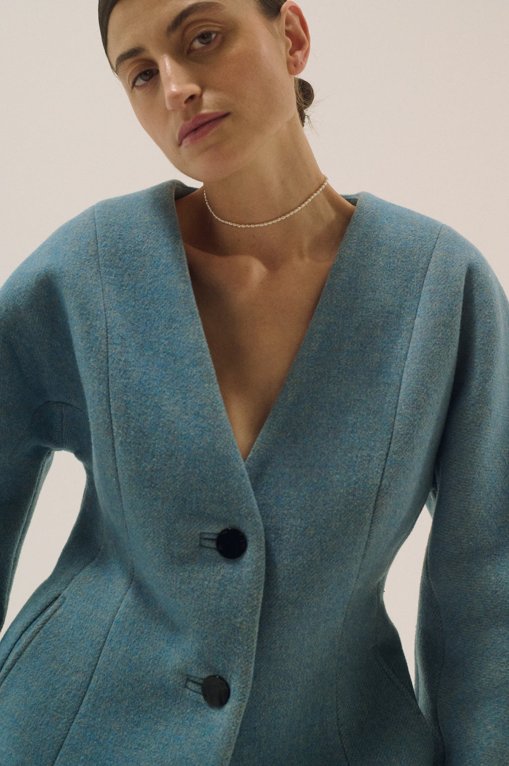 Model wearing delicate tiny freshwater pearl choker with blue blazer