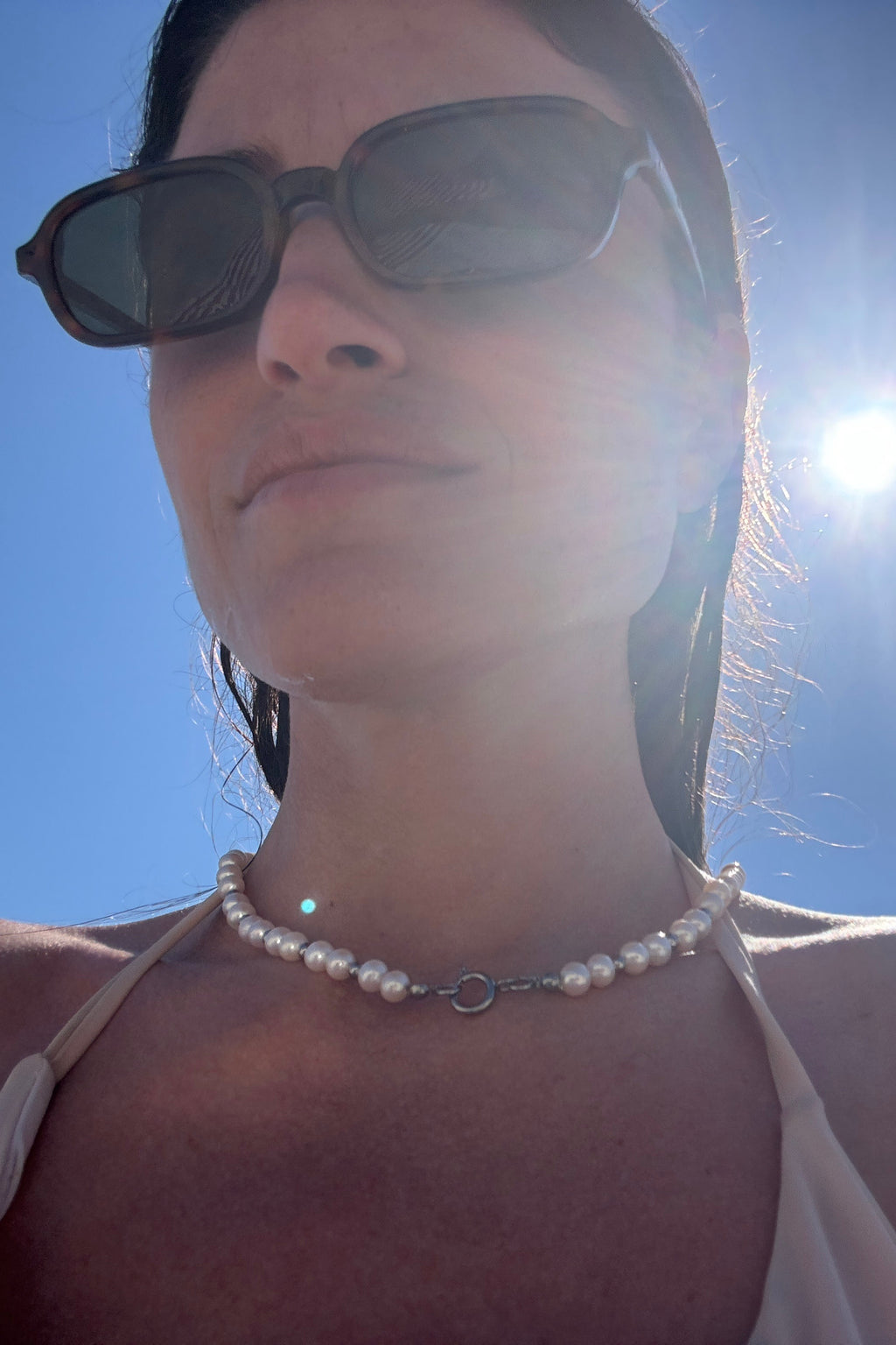 Classic freshwater pearl necklace made with round white pearls and small metal beads.