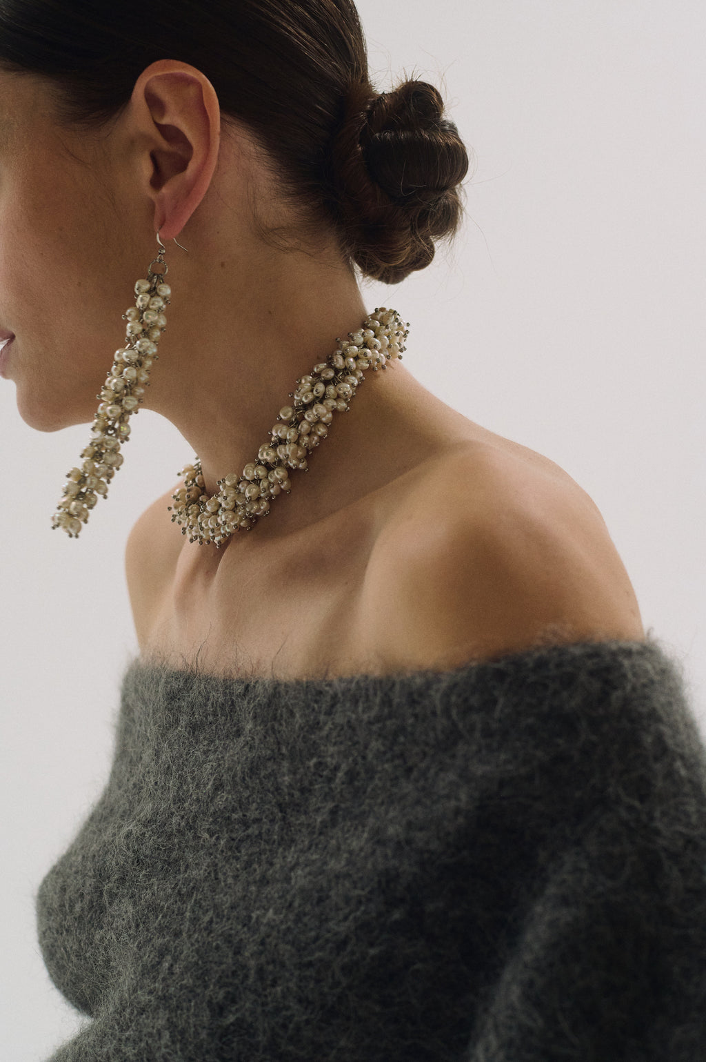 Close-up of oversized dramatic pearl earrings and choker set