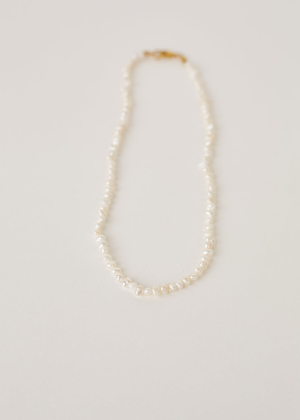 Pearl necklace on a light gray background