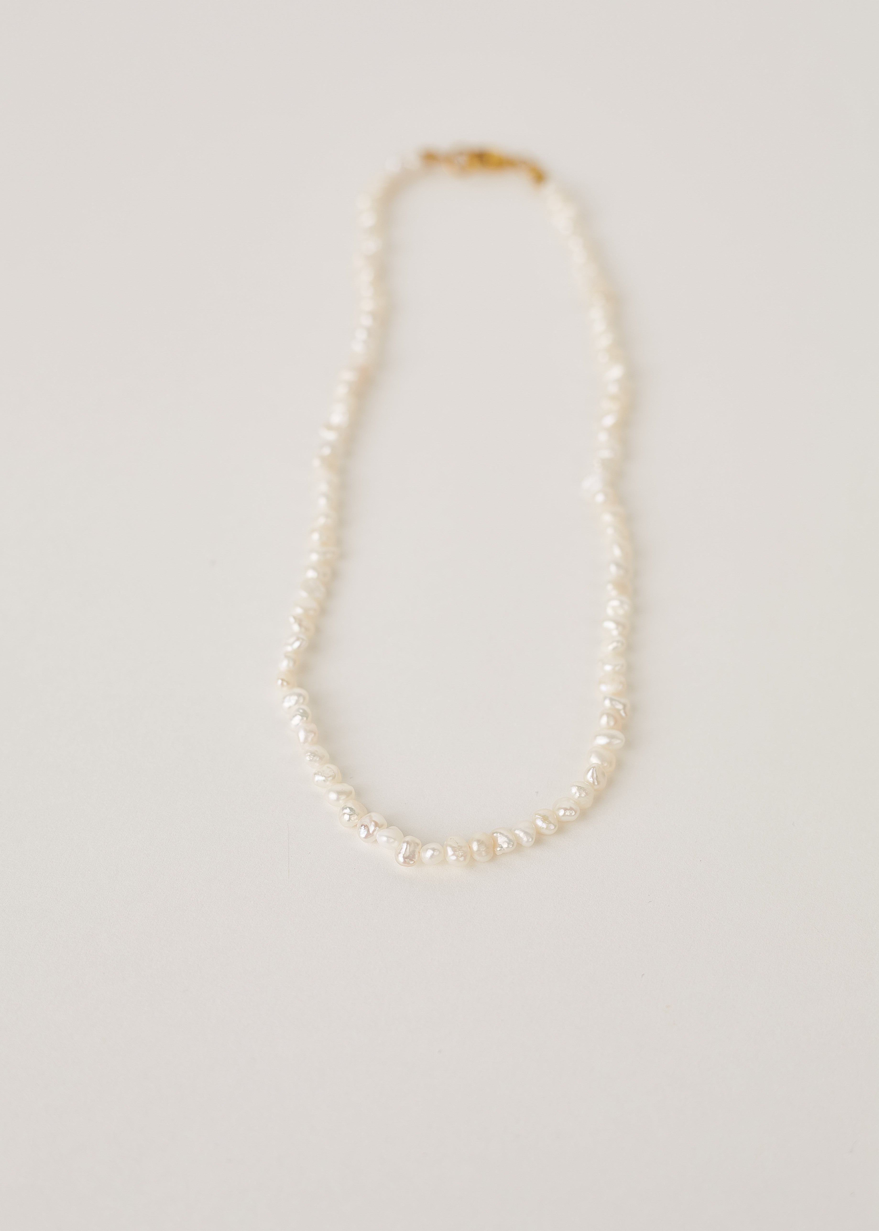 Pearl necklace on a light gray background