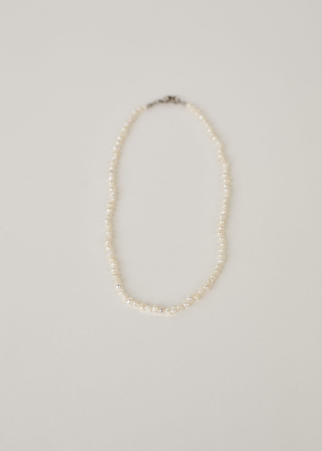 Pearl necklace on a light gray background