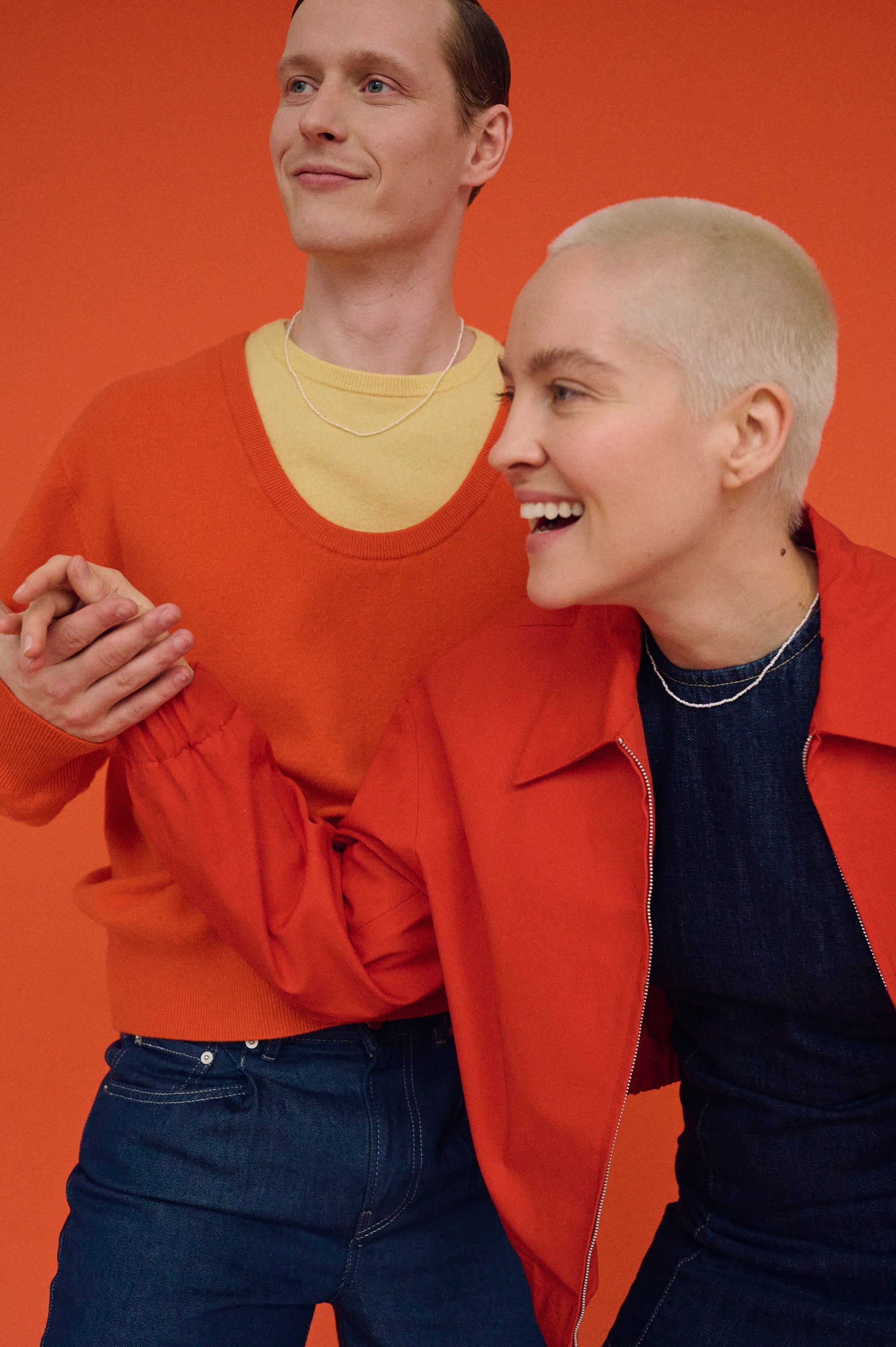 Couple wearing matching tiny pearl necklaces, modern unisex jewelry look.