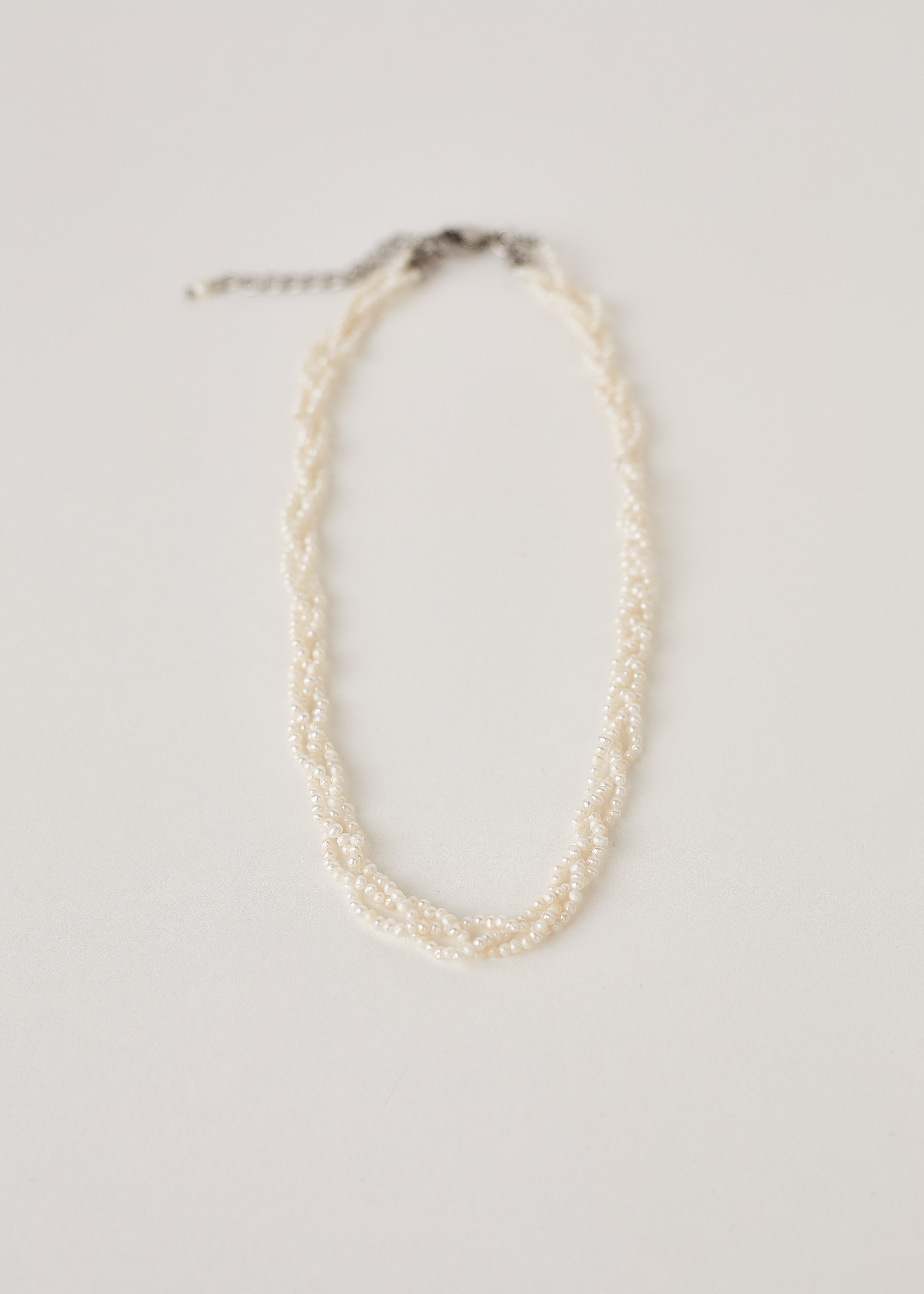 Multistrand real tiny white Pearl necklace on a light gray background