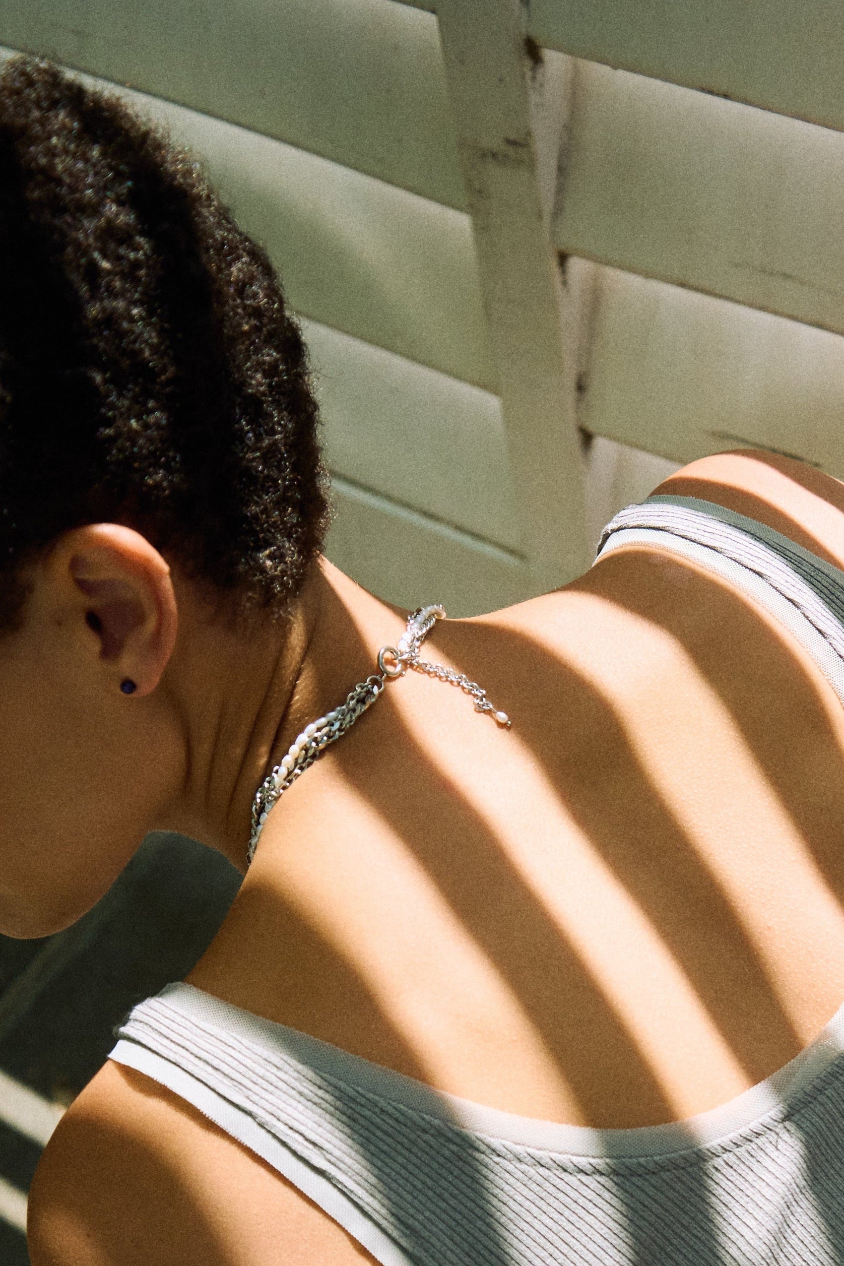 Braided pearl and chain choker styled with a minimal grey top.