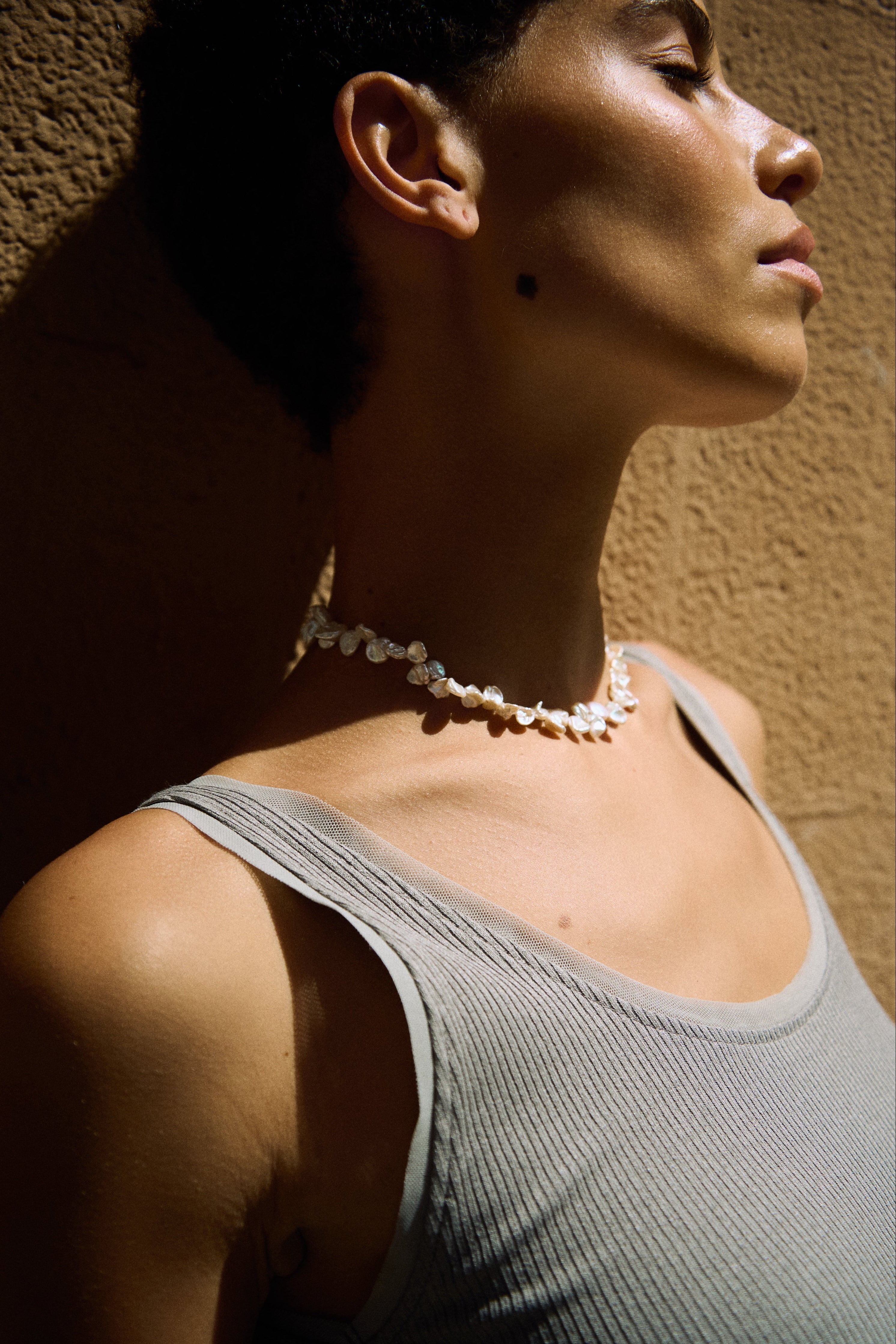 Drop pearl necklace styled with a minimal grey top.