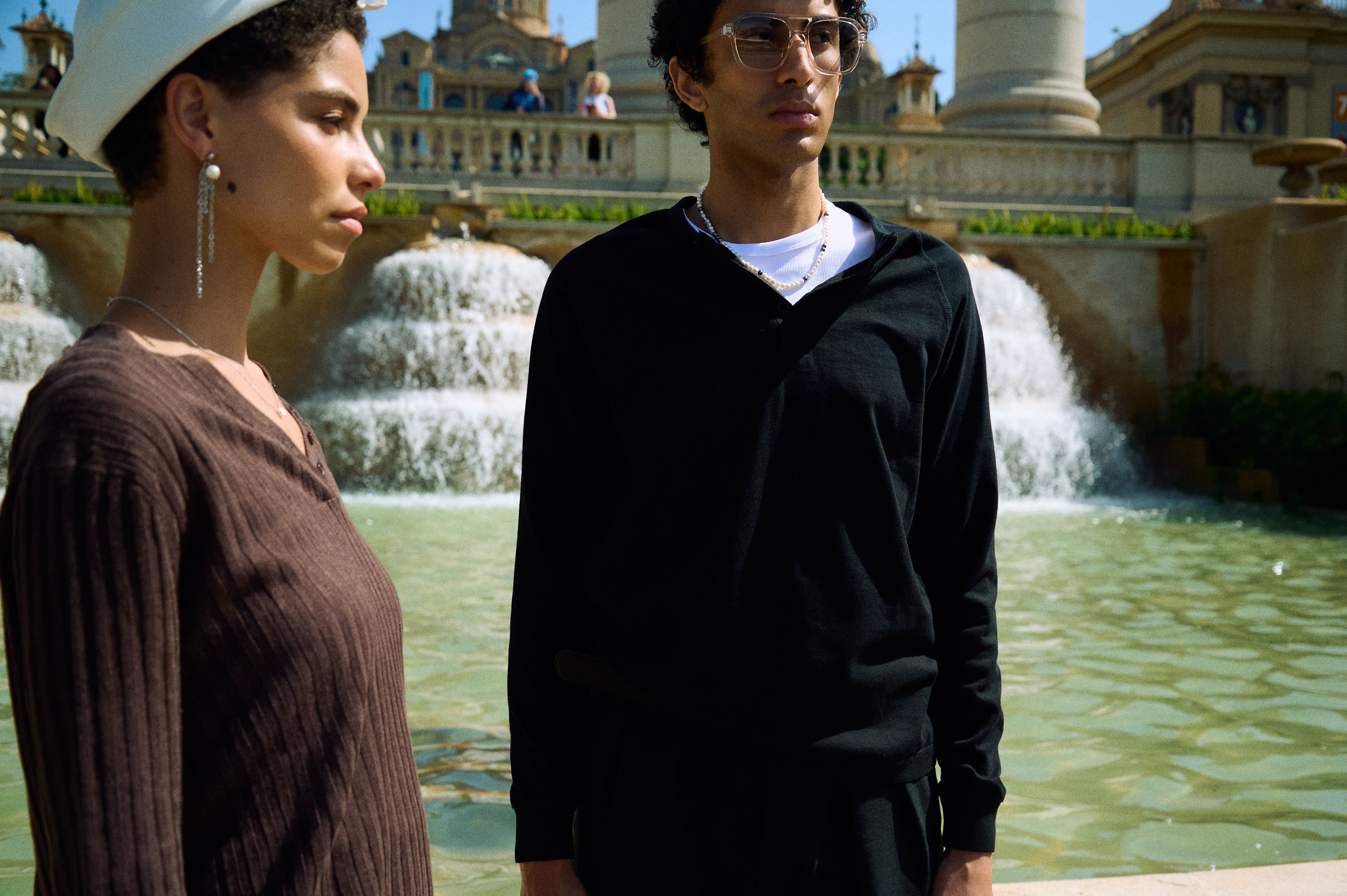 Men’s peacock pearl necklace styled with a white T-shirt and black top.