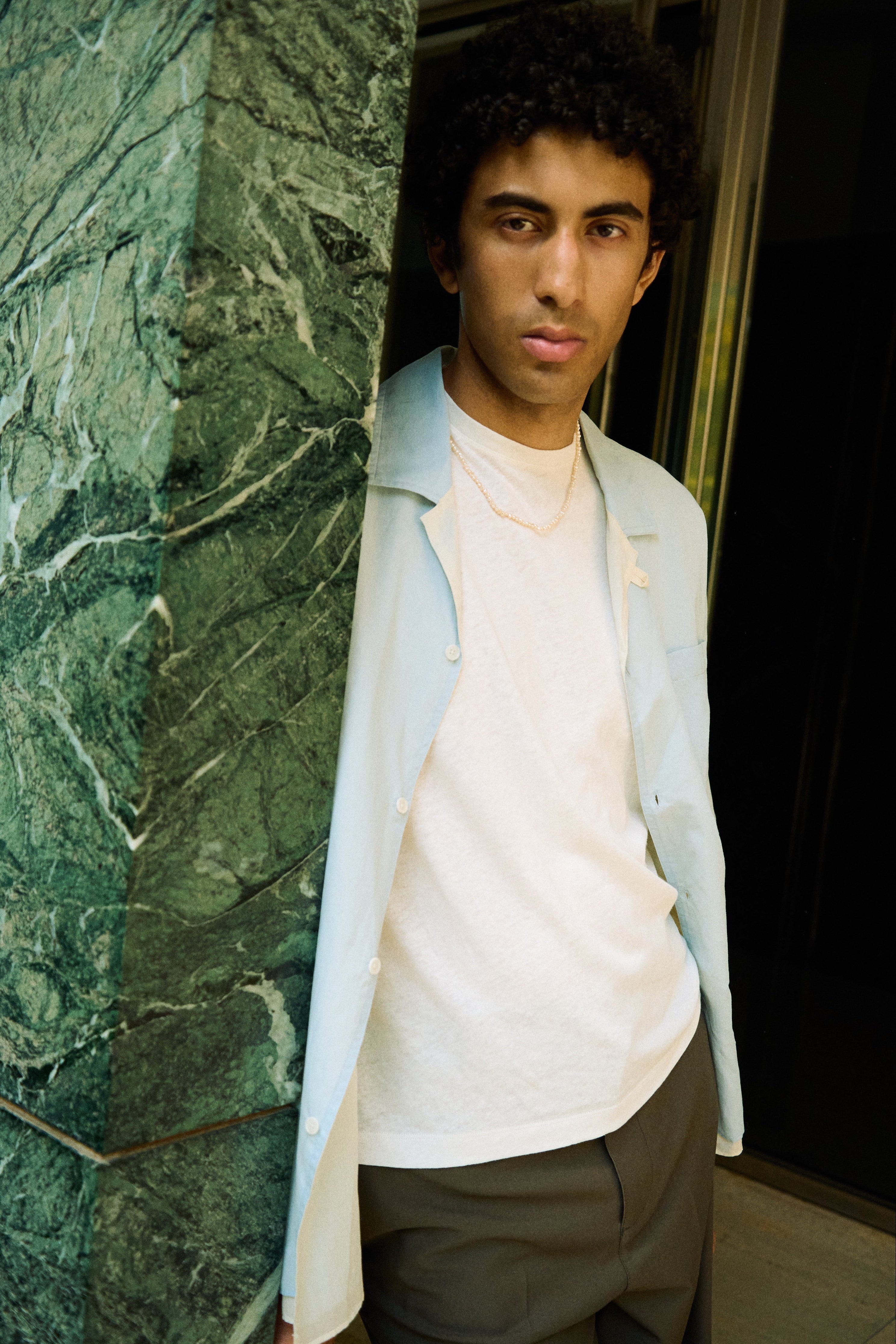 Man wearing a men’s nugget freshwater pearl necklace with small white pearls.