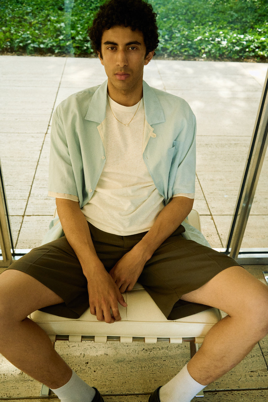 Man wearing a minimal single pearl necklace on a fine chain.