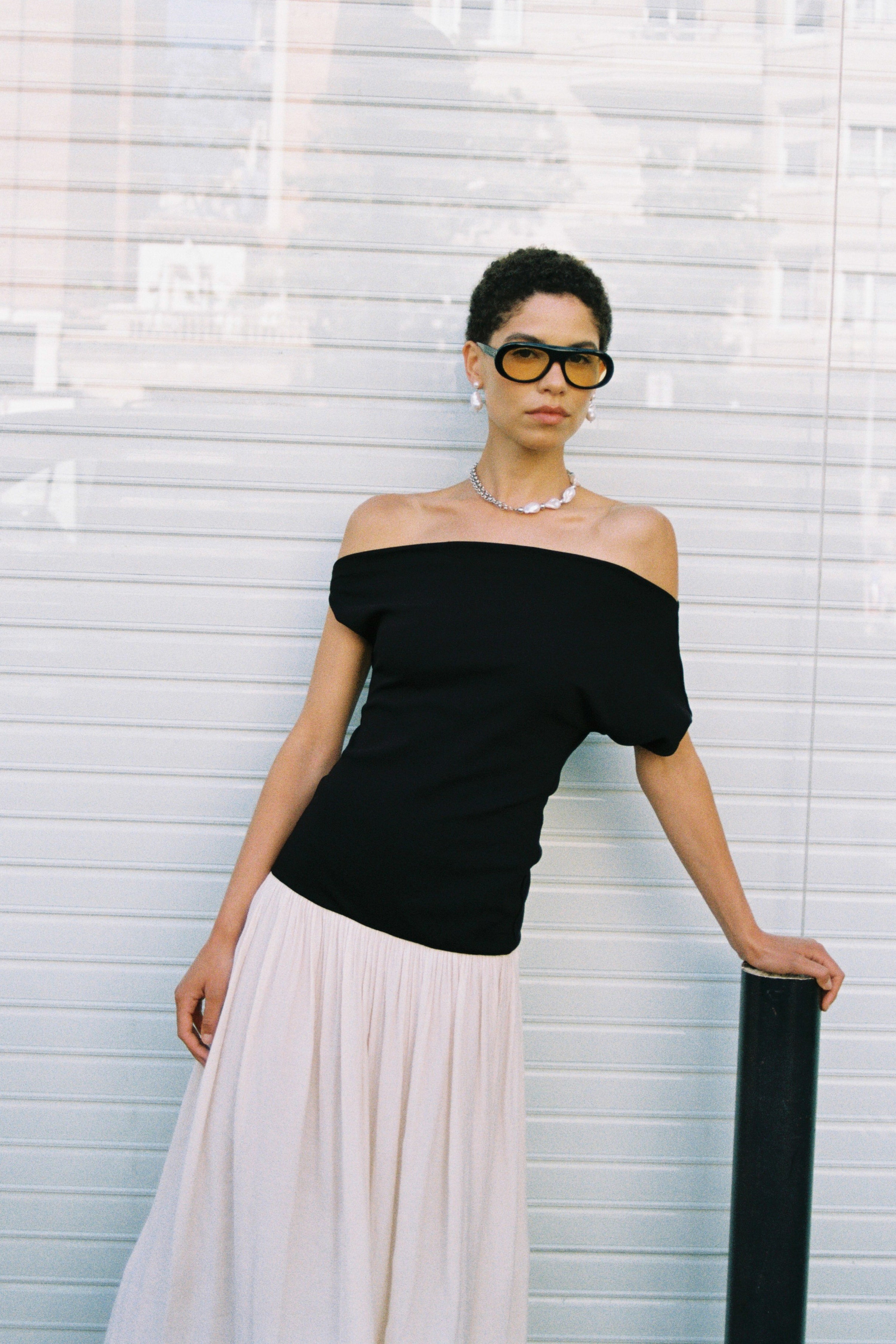 Model wearing a half double chain, half baroque freshwater pearl necklace with hand-knotted pearls and black off-shoulder top.