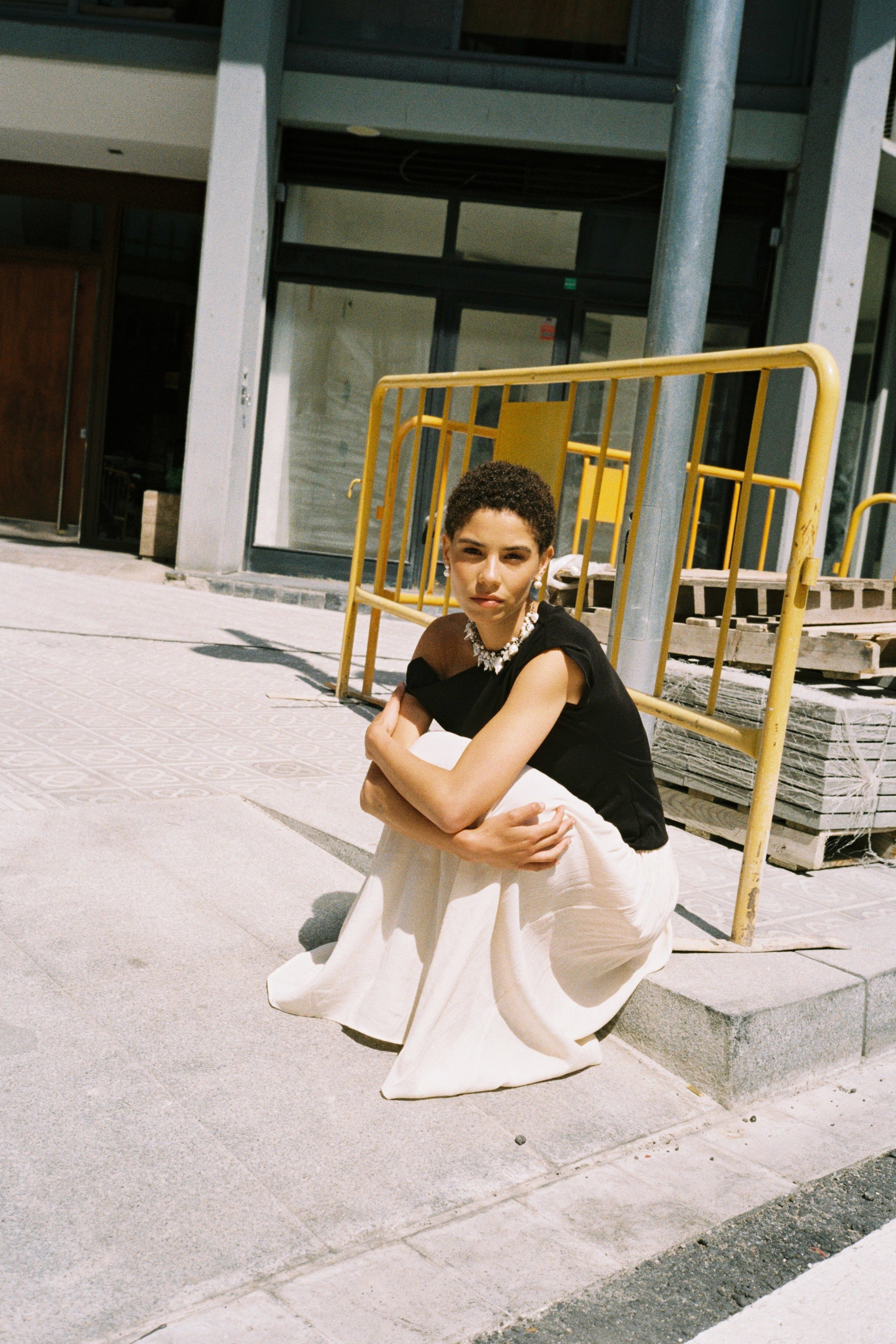 Statement pearl choker styled with a black off-shoulder top.