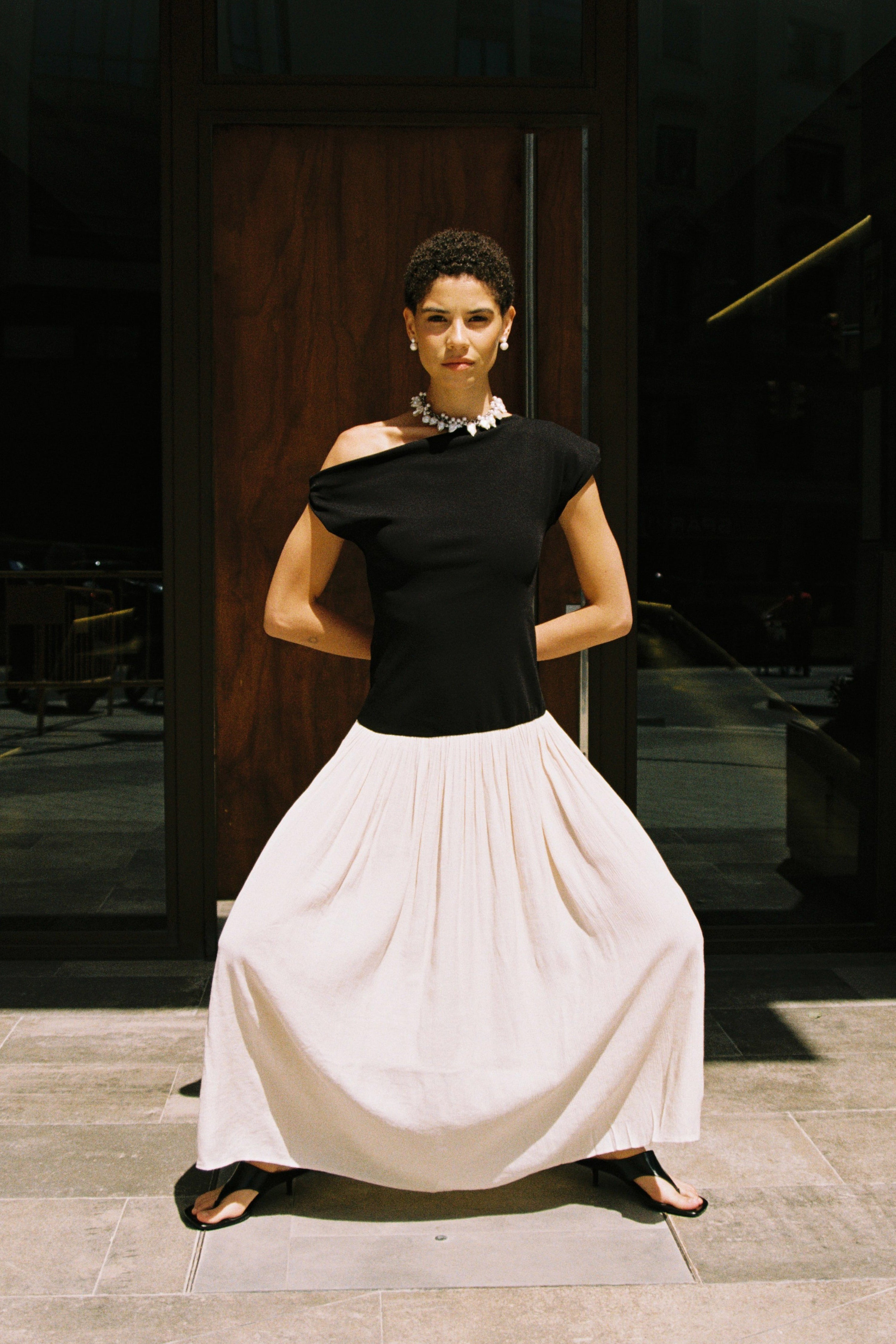 Statement pearl choker styled with a black off-shoulder top.