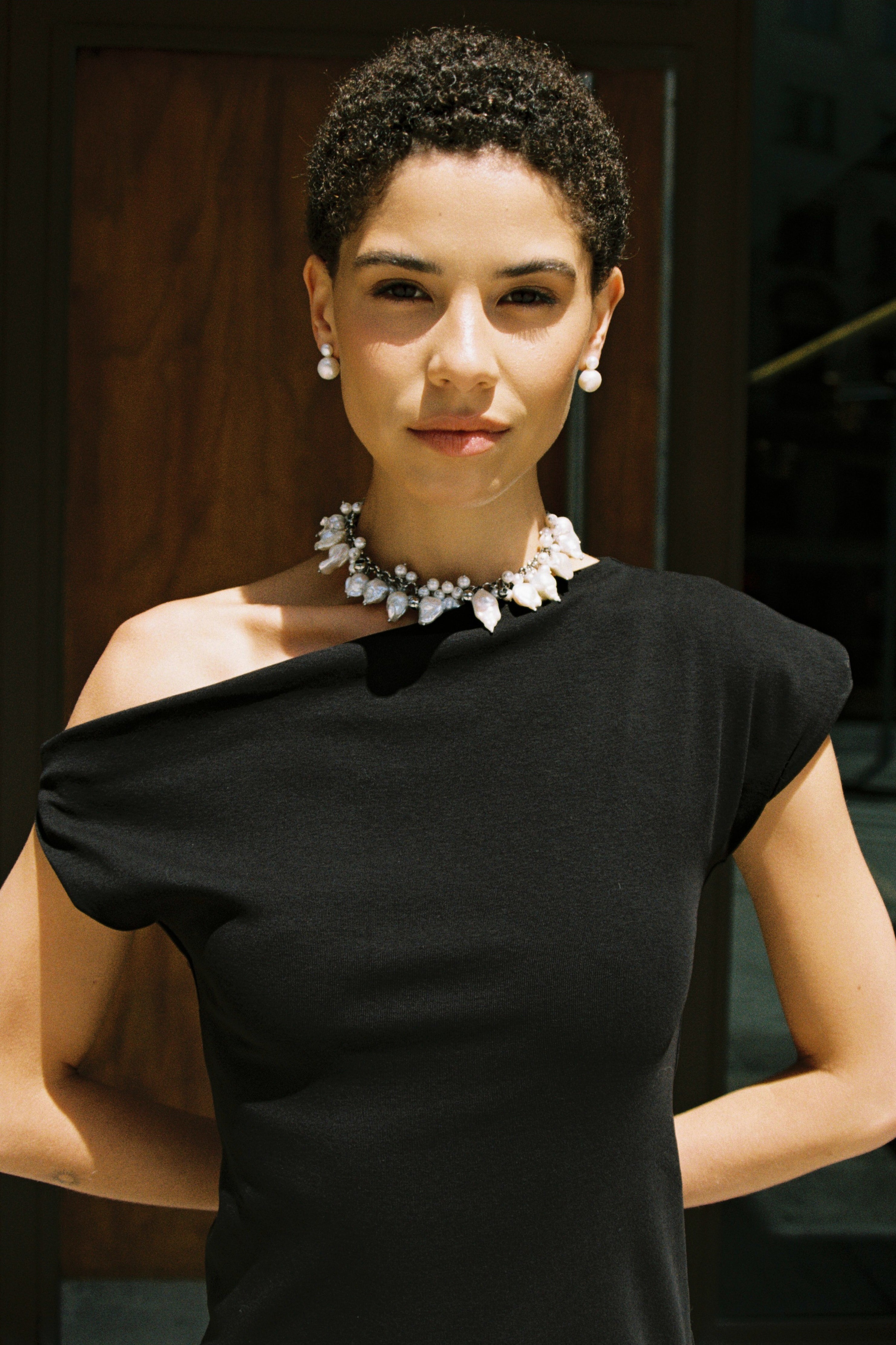 Model wearing a statement pearl choker with baroque freshwater pearls, round pearls, and metal beads.