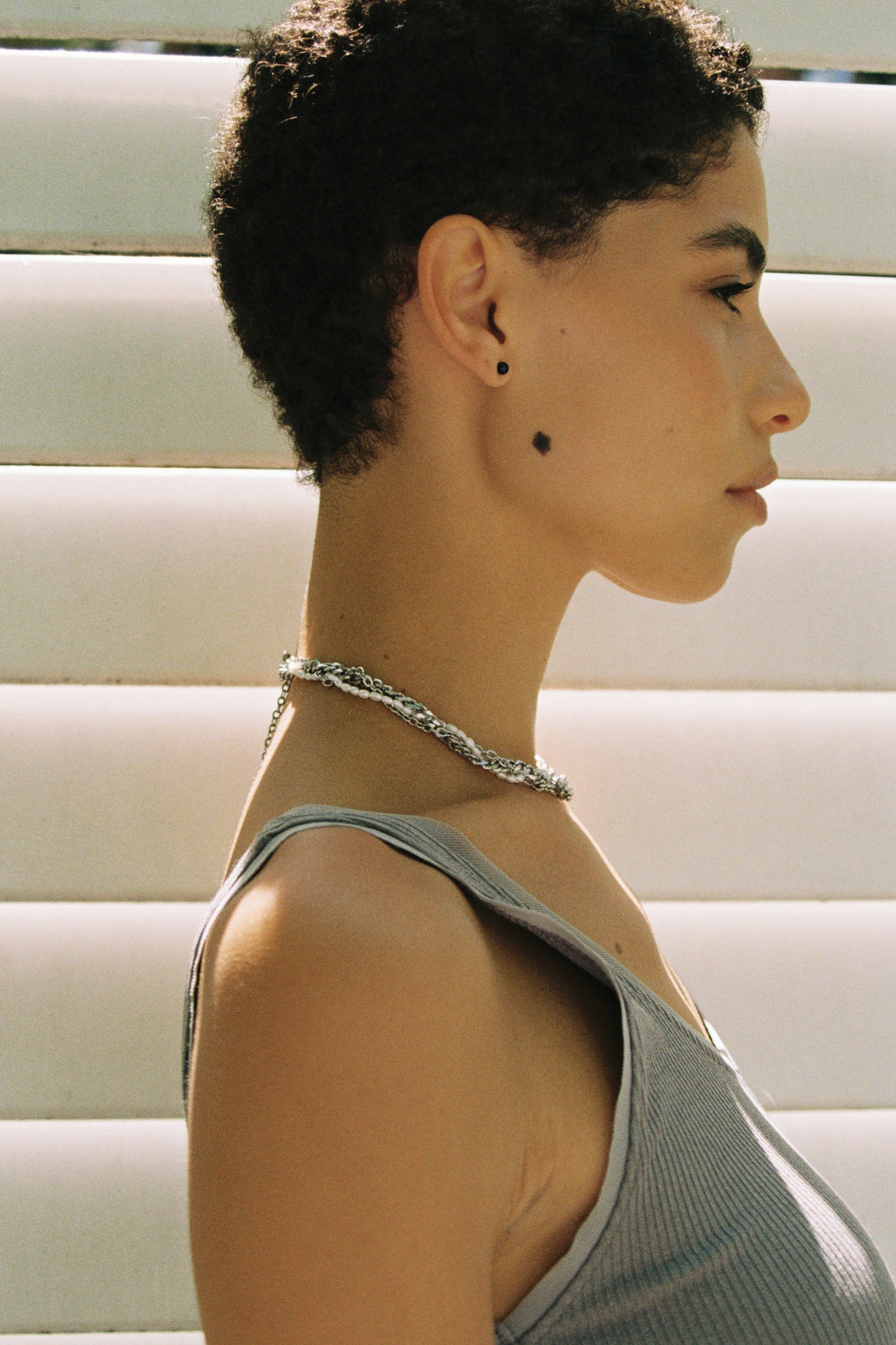 Model wearing minimal dark blue freshwater pearl stud earrings.