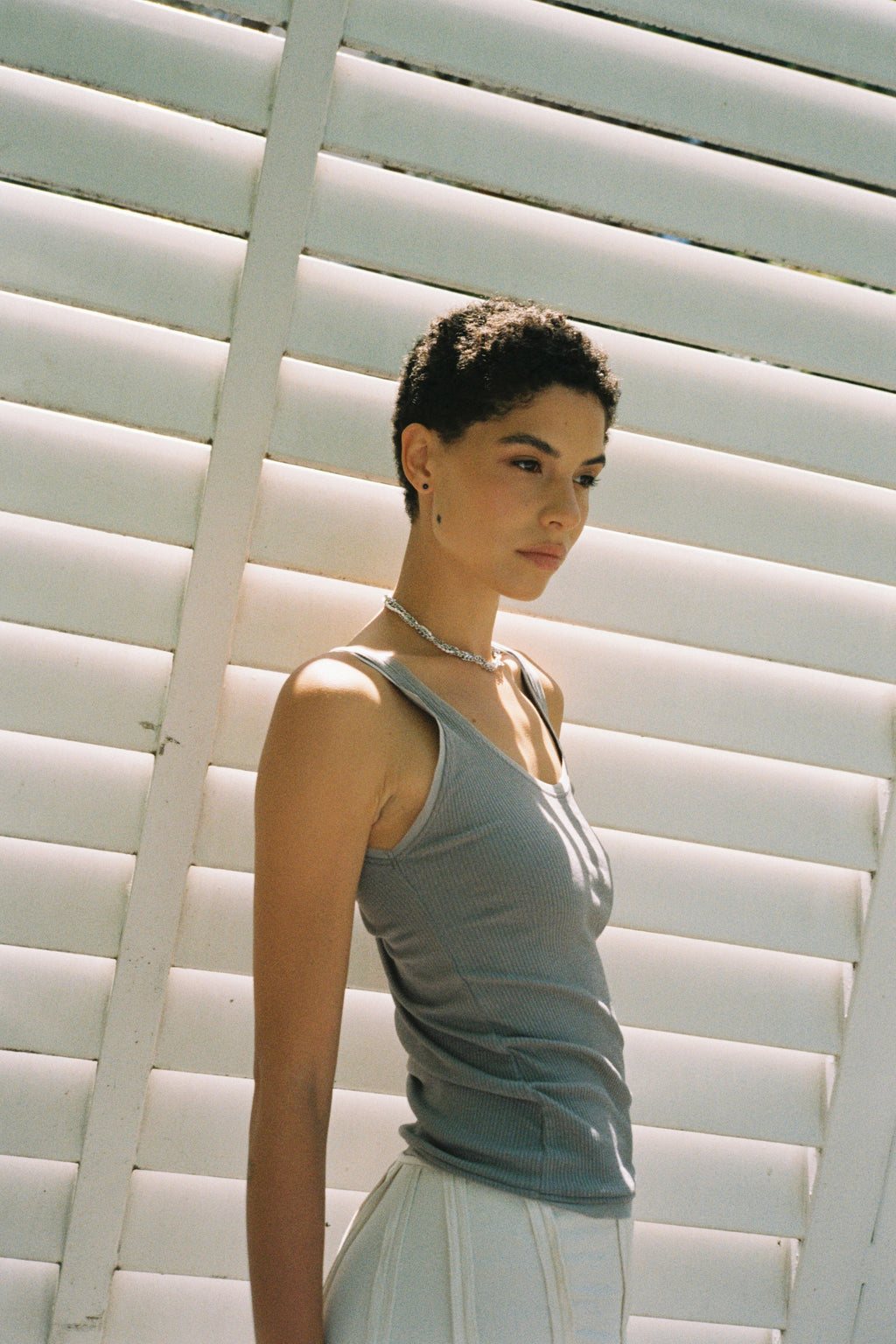 Model wearing minimal dark blue freshwater pearl stud earrings.