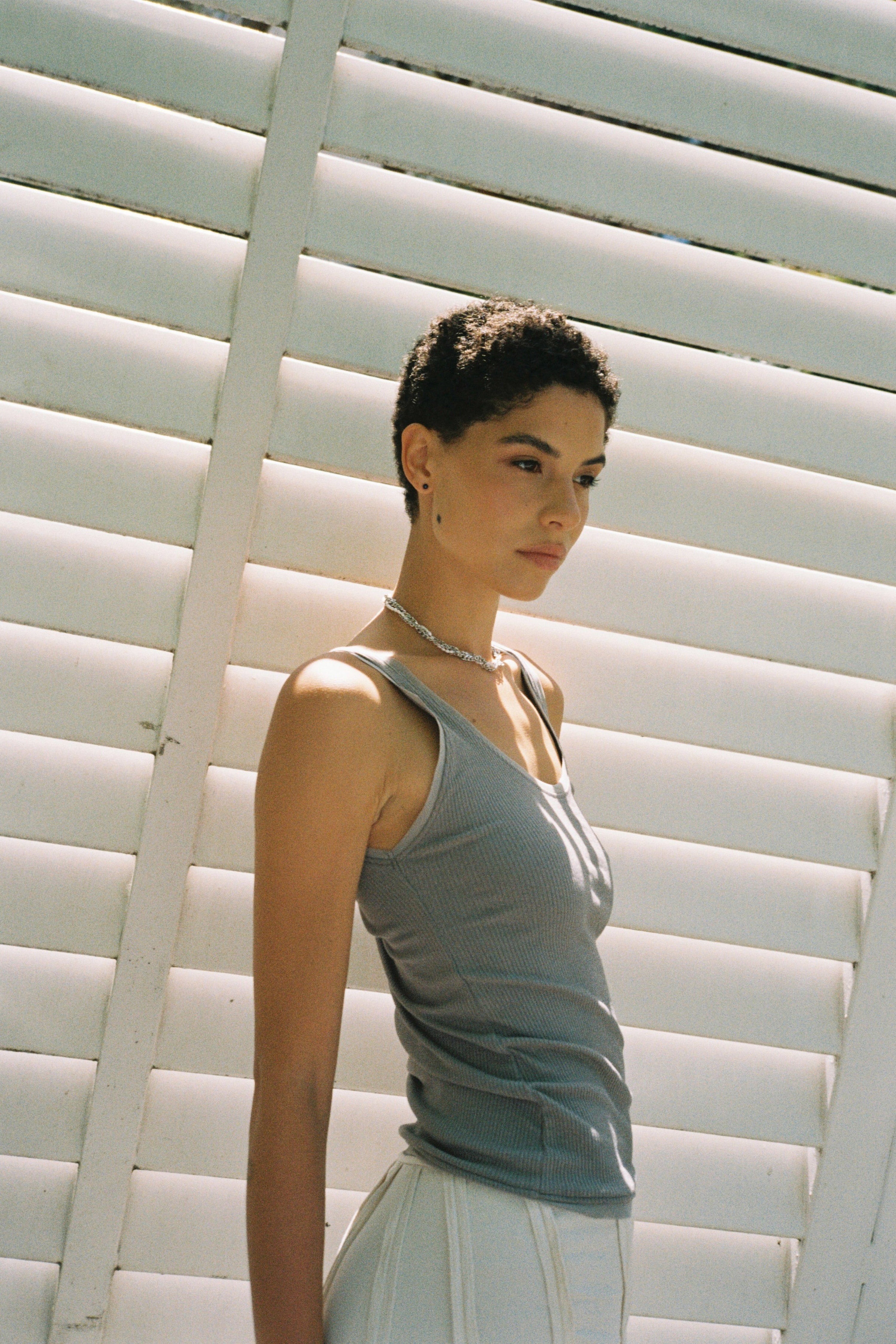 Model wearing minimal dark blue freshwater pearl stud earrings.