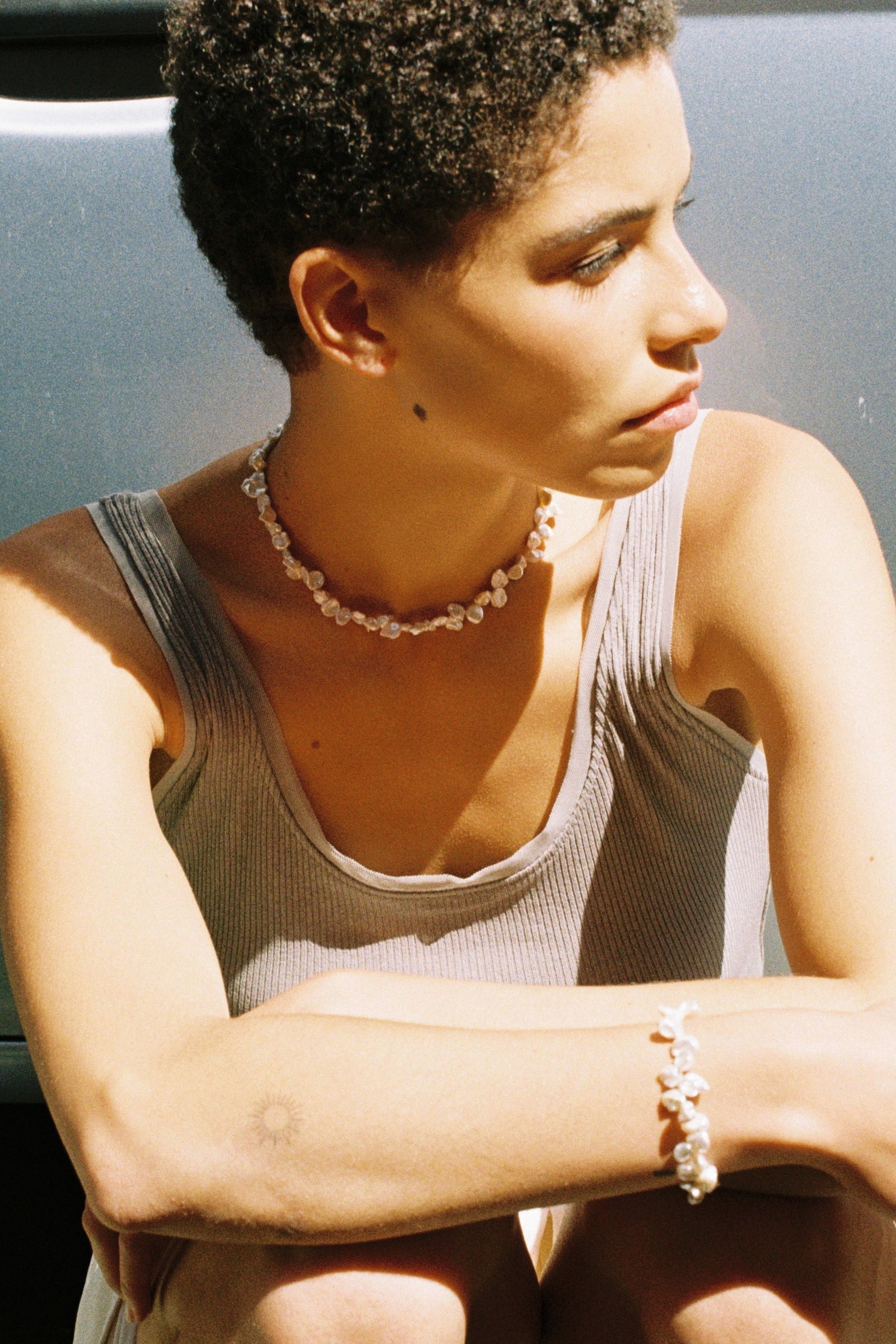 Model wearing a drop freshwater pearl necklace with softly irregular natural pearls.