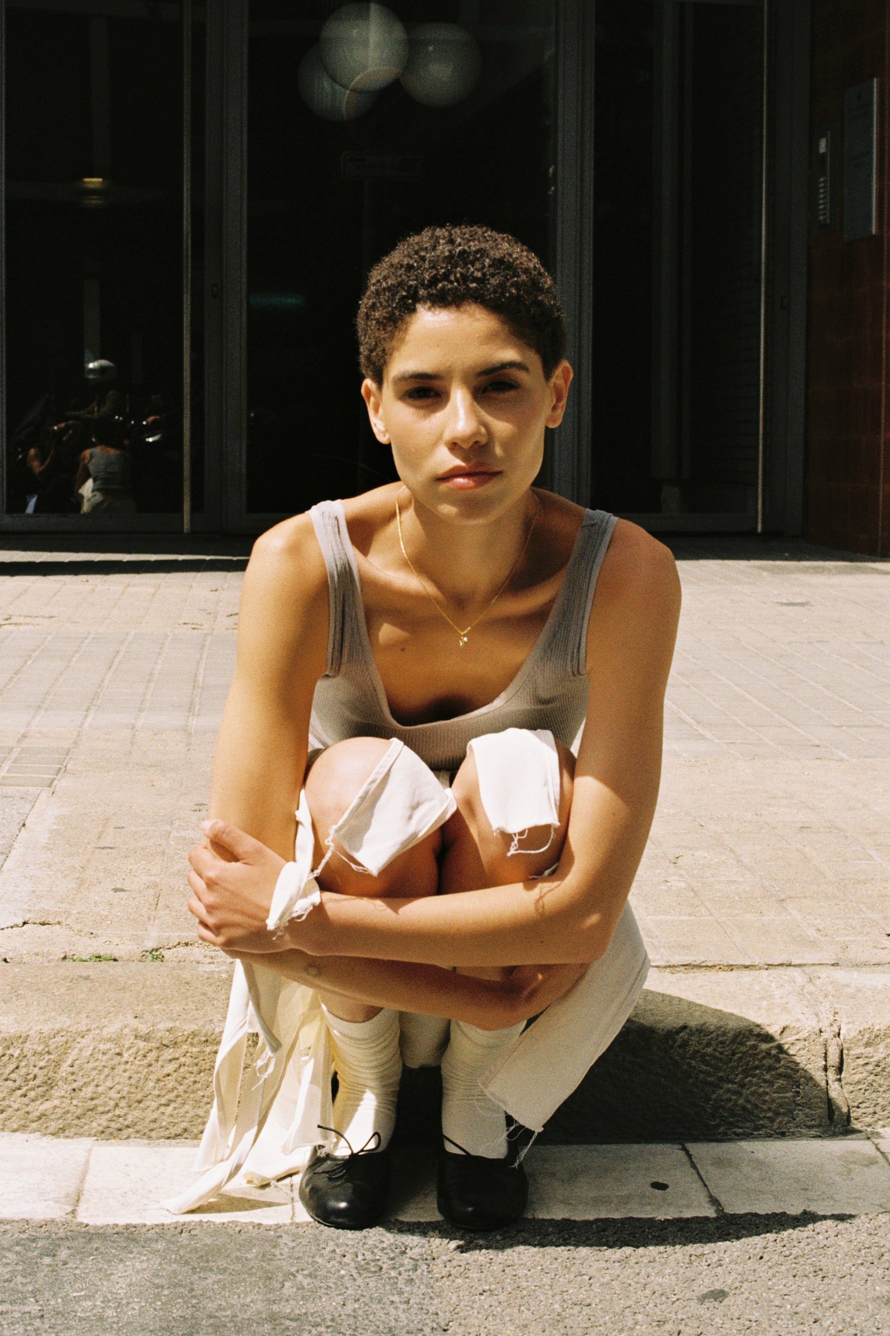 Model wearing a delicate initial necklace with a small letter pendant and tiny freshwater pearl.
