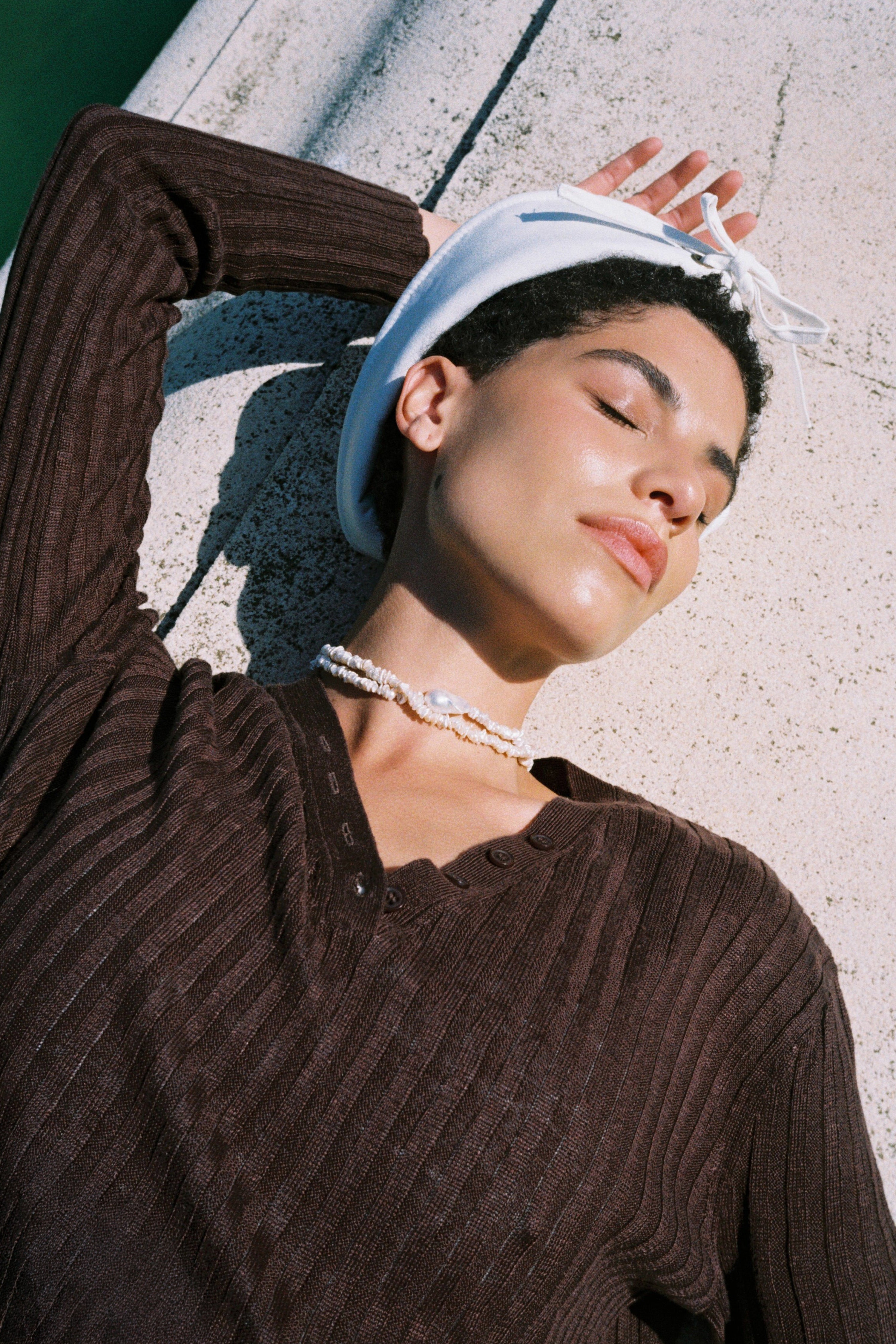Model wearing a baroque keshi pearl necklace with white keshi pearls and a central baroque pearl.