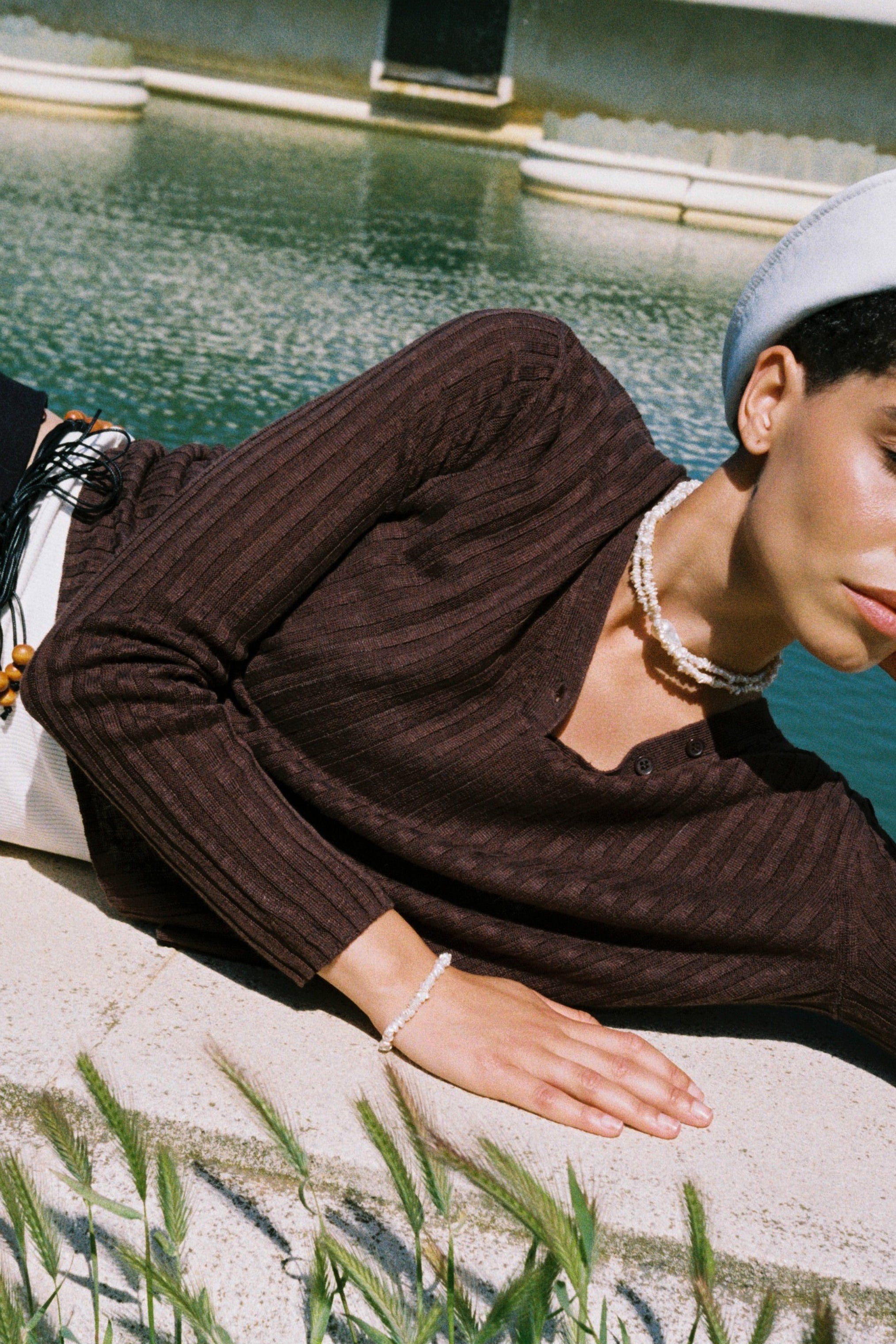 Model wearing a baroque keshi pearl necklace with white keshi pearls and a central baroque pearl.